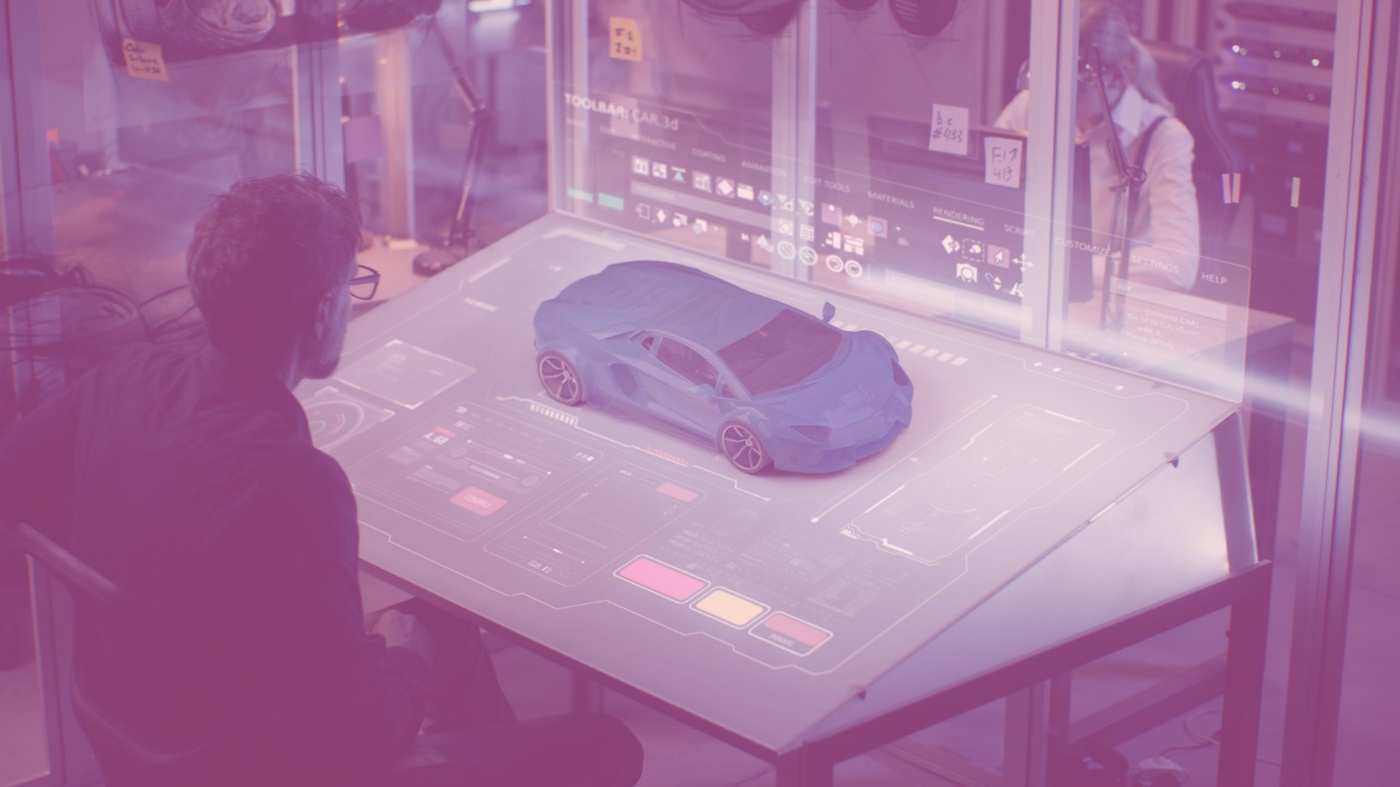 Person betrachtet dreidimensionale Darstellung eines Auto auf einem Arbeitstisch.