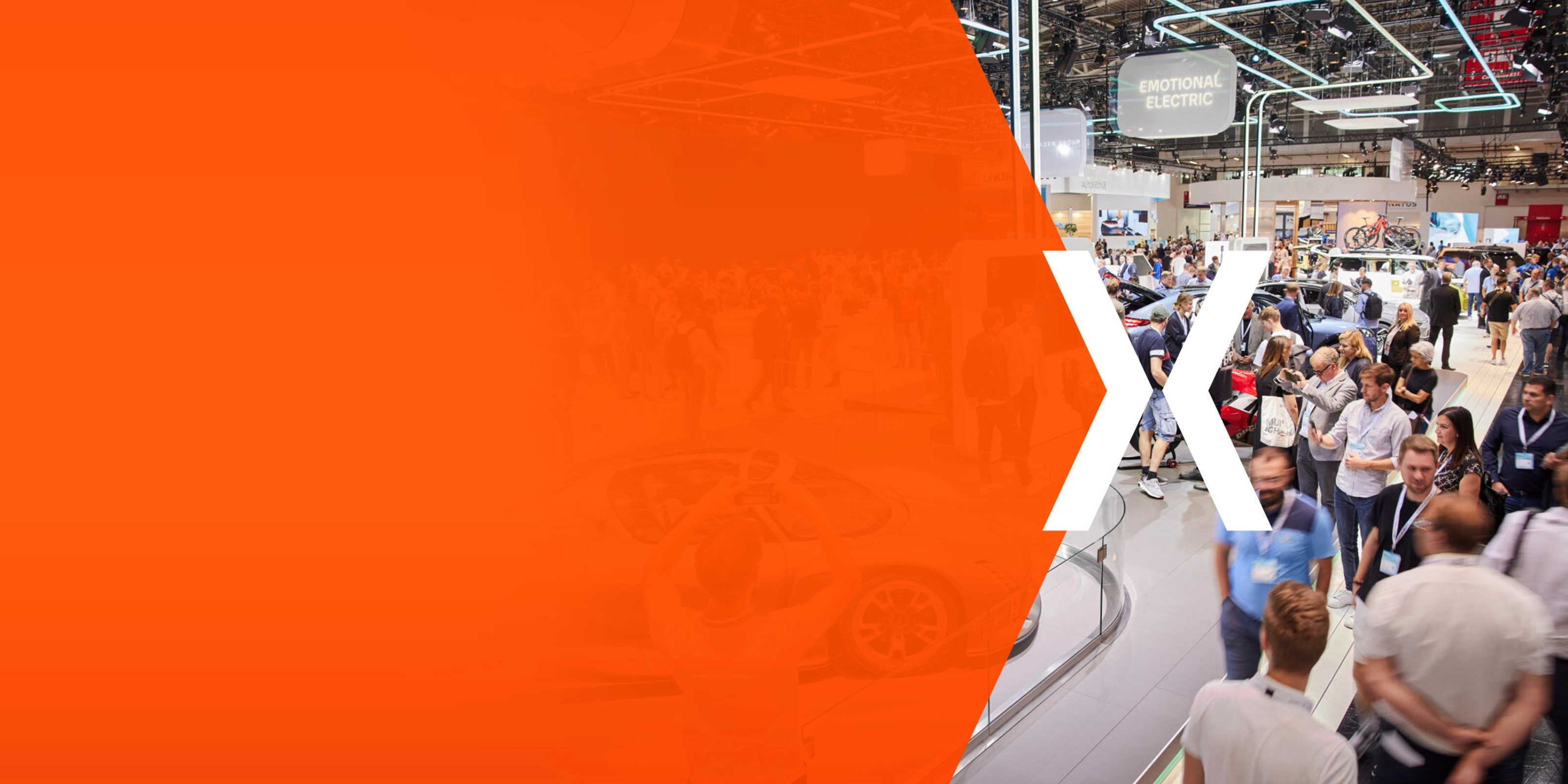 Messehalle mit vielen Besuchern und einer orangefarbenen Fläche mit großem weißem X.