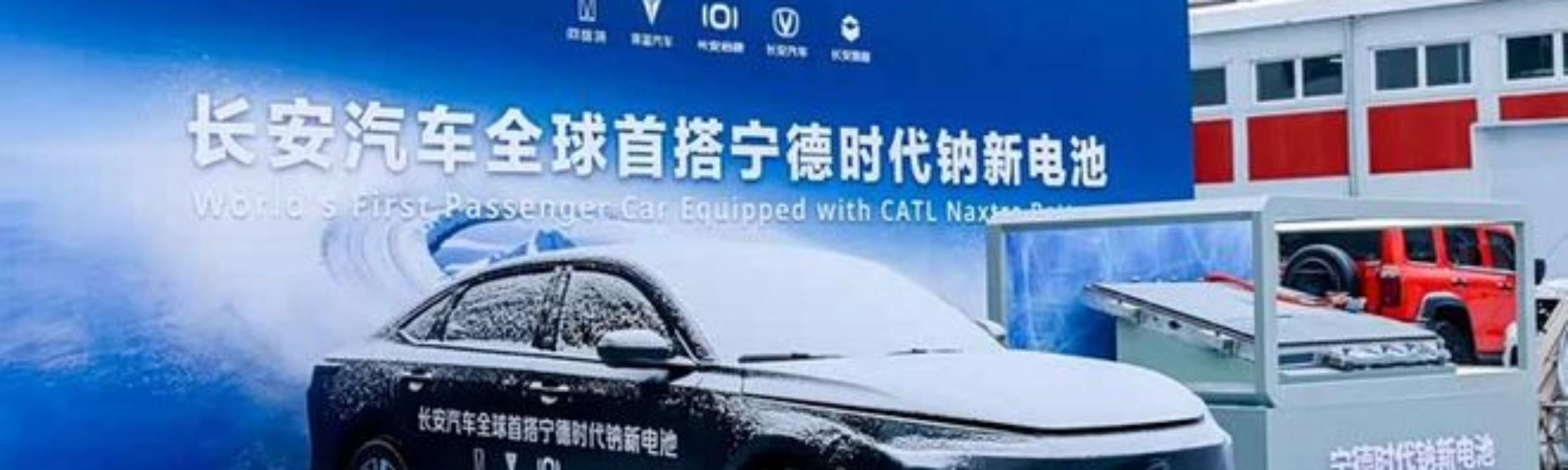 Elektroauto im Schnee vor Messestand mit chinesischem Banner.