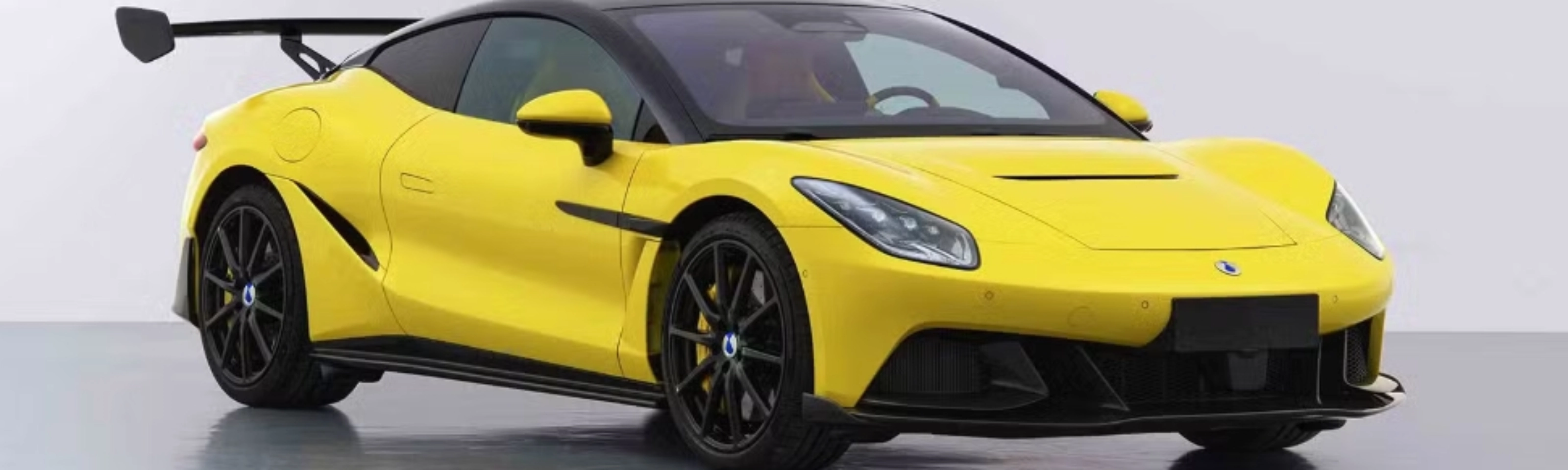 Yellow Denza Z sports car by BYD with rear wing on white studio background.