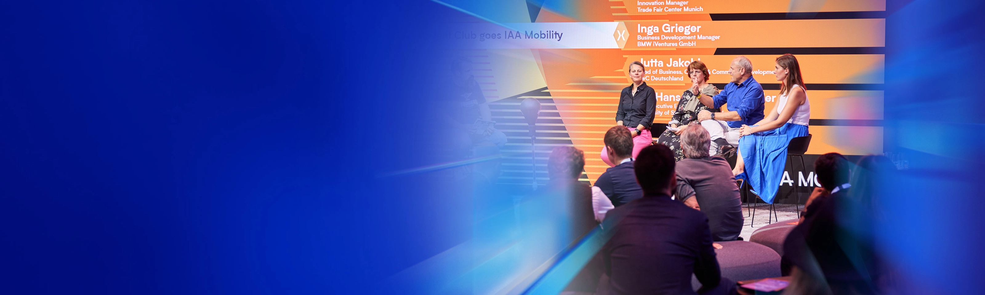 Ein Panel mit fünf Personen spricht auf der Bühne des IAA Summit, das Publikum hört zu.