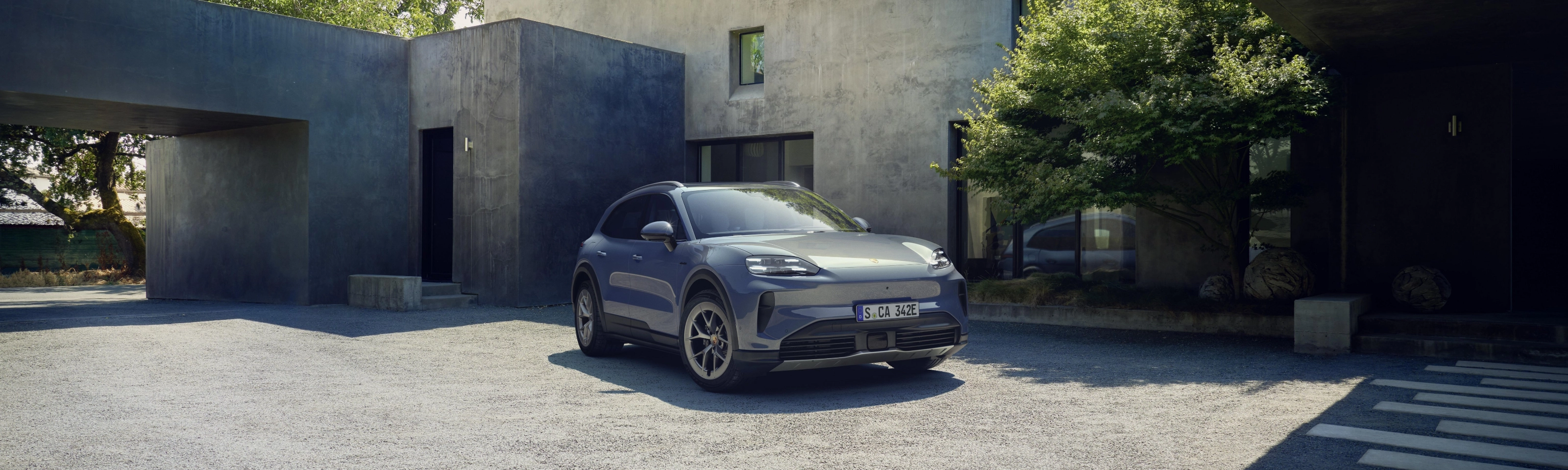 Porsche Cayenne S parked in front of a modern house.