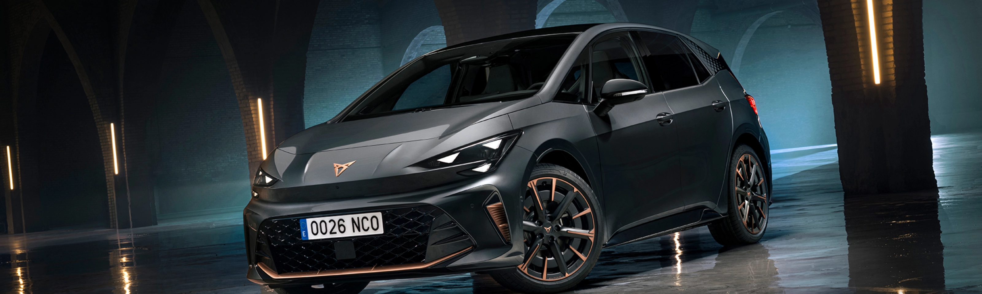 CUPRA Elektroauto steht in einer dunklen Halle mit Bögen und spiegelndem Boden.