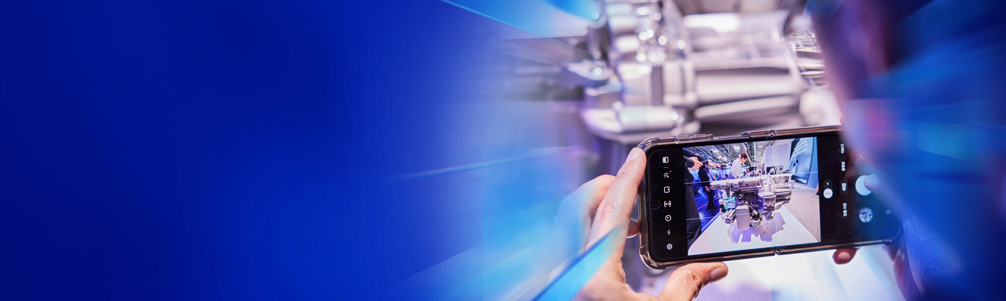 Eine Person fotografiert ein technisches Exponat mit dem Smartphone auf dem IAA Summit.