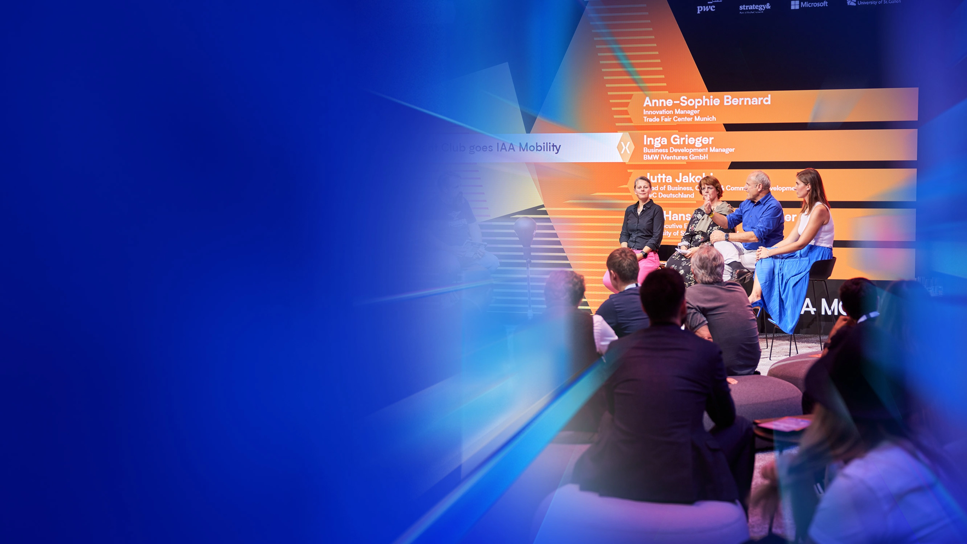 Ein Panel mit fünf Personen spricht auf der Bühne des IAA Summit, das Publikum hört zu.