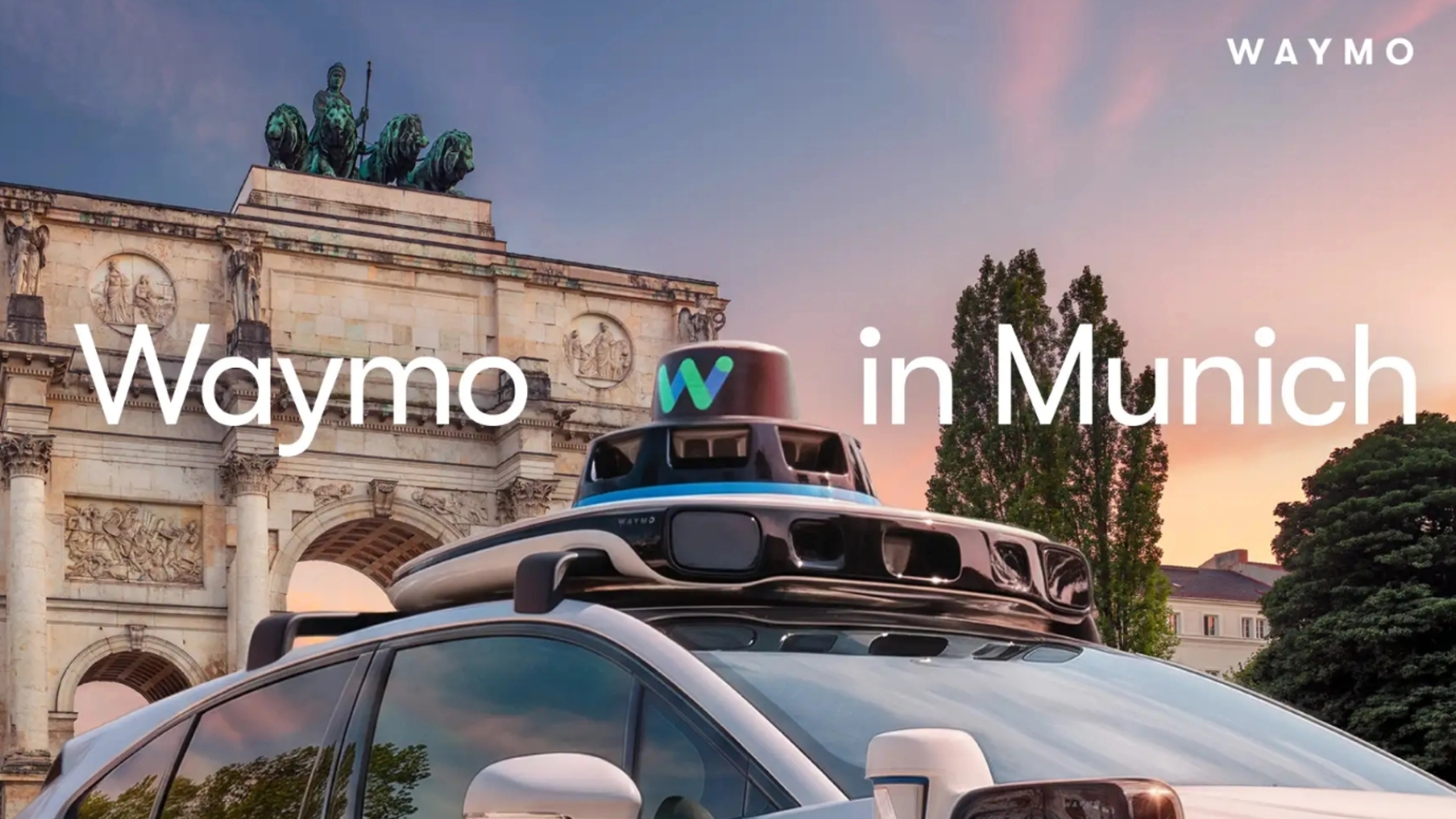 Autonomes Waymo Fahrzeug mit Dachsensoren vor einem Münchner Wahrzeichen.