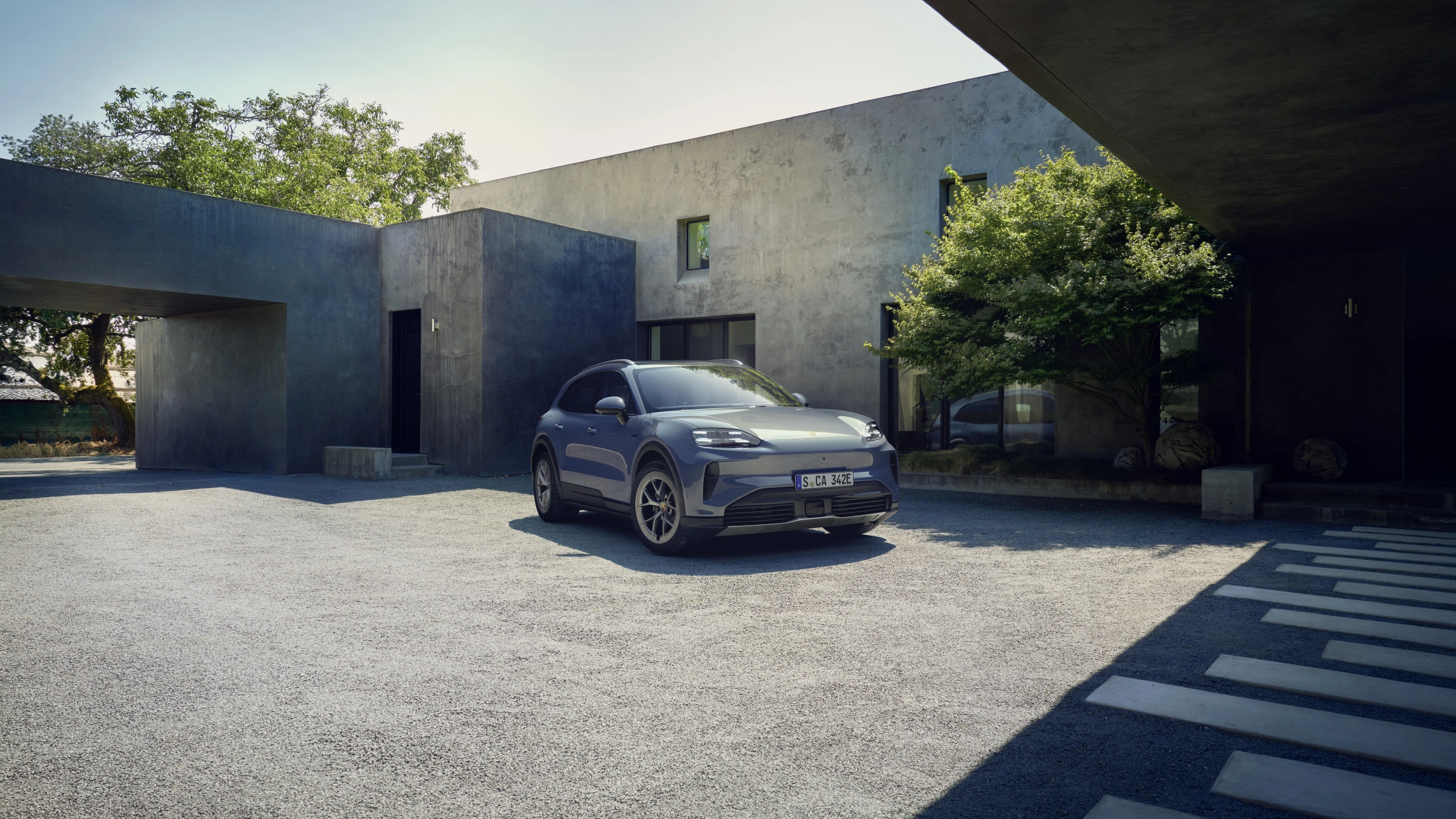 Porsche Cayenne S parked in front of a modern house.