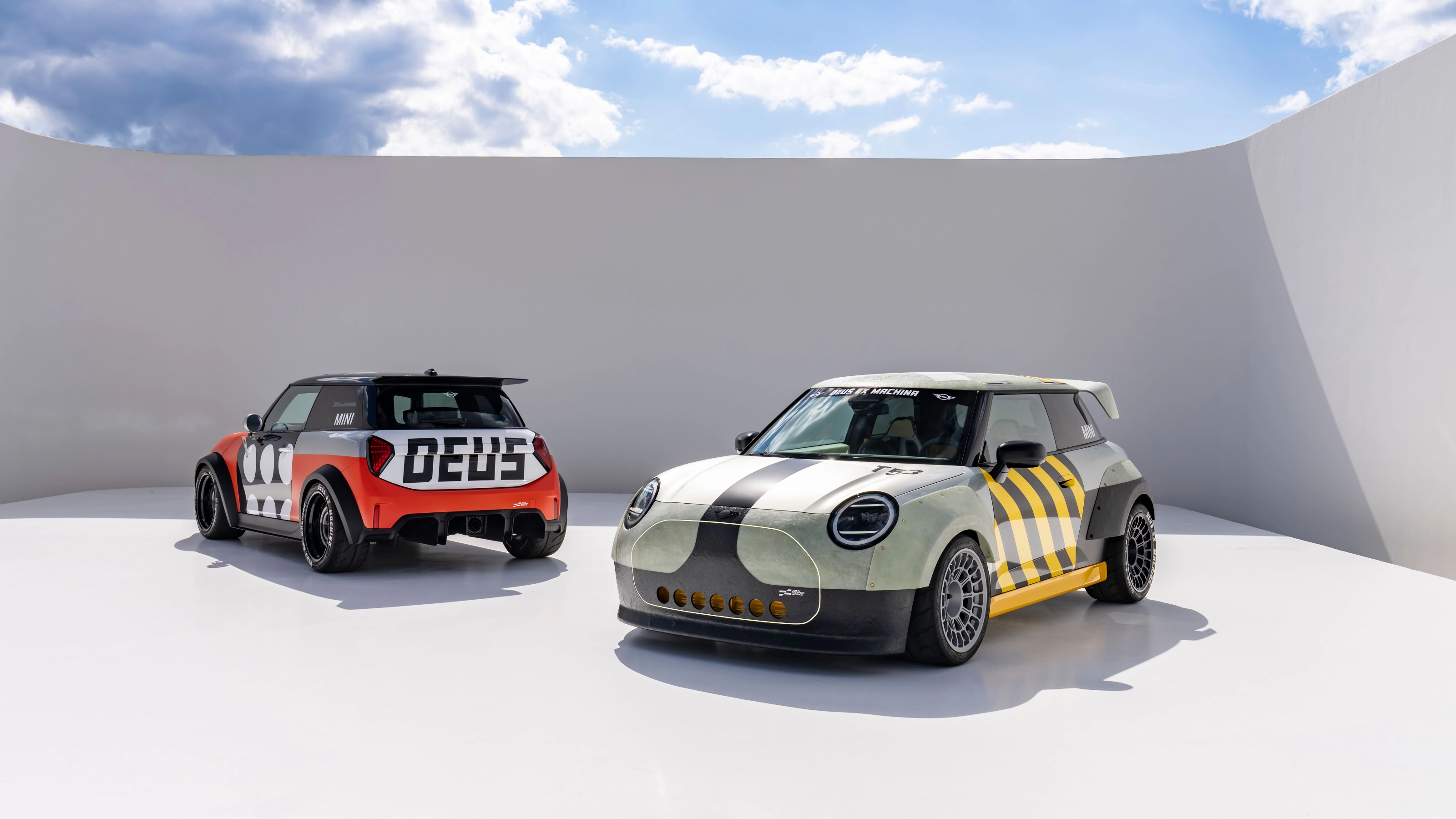Two customized Mini cars parked in a minimalist outdoor setting.