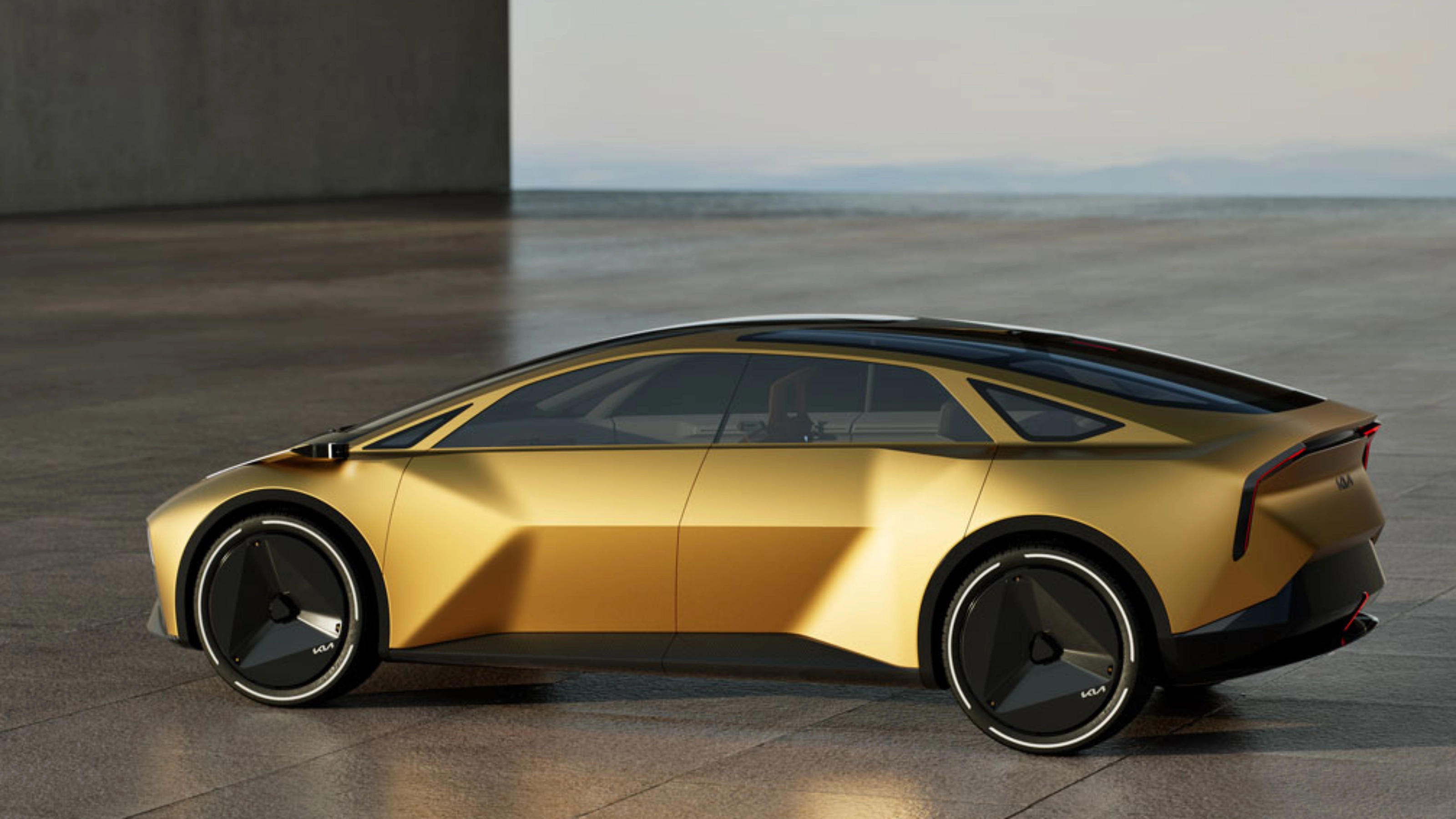 Goldenes Konzeptauto in Seitenansicht auf freier Betonfläche.