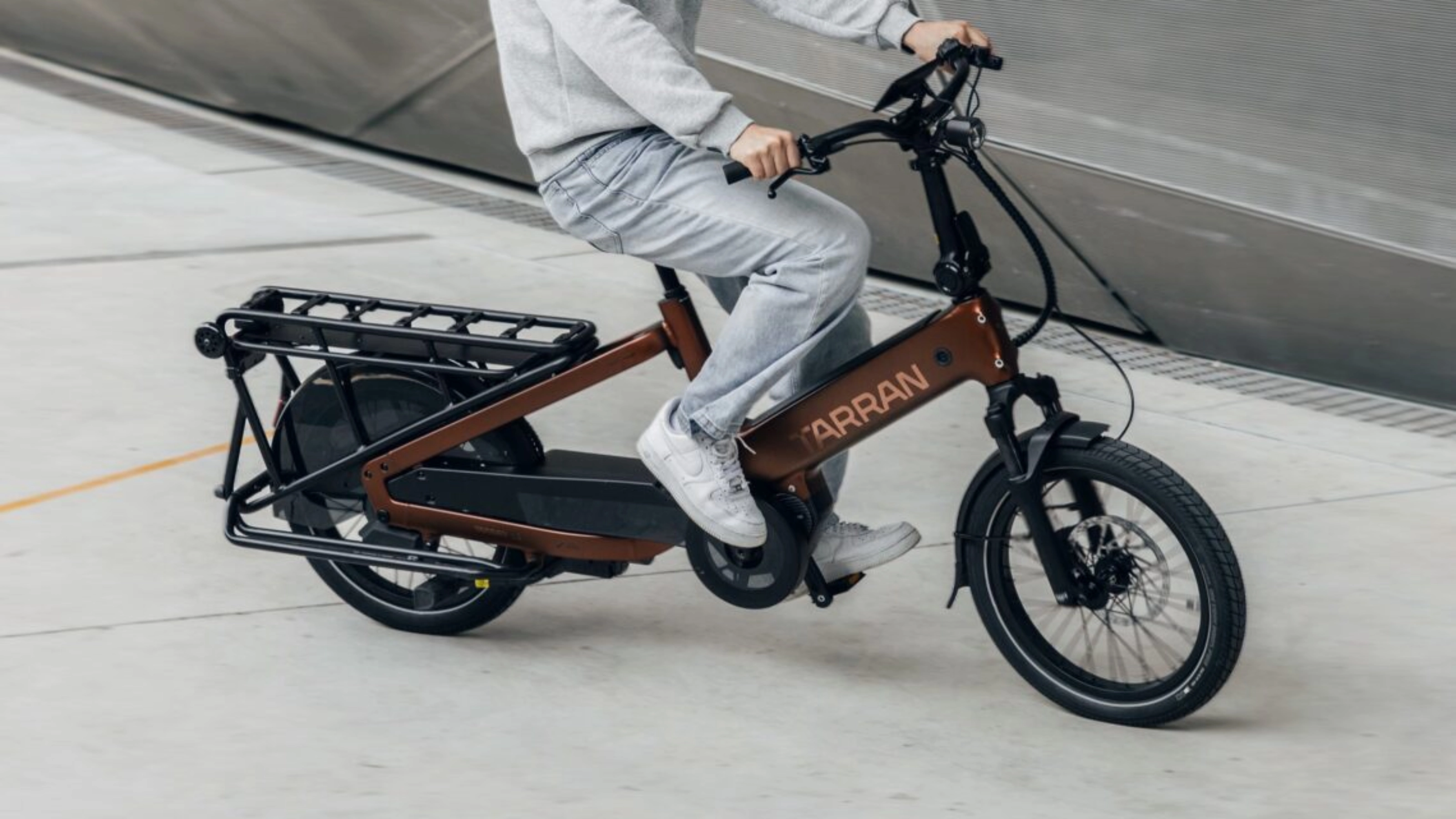 Person fährt ein Tarran Lasten-E-Bike in urbaner Umgebung.