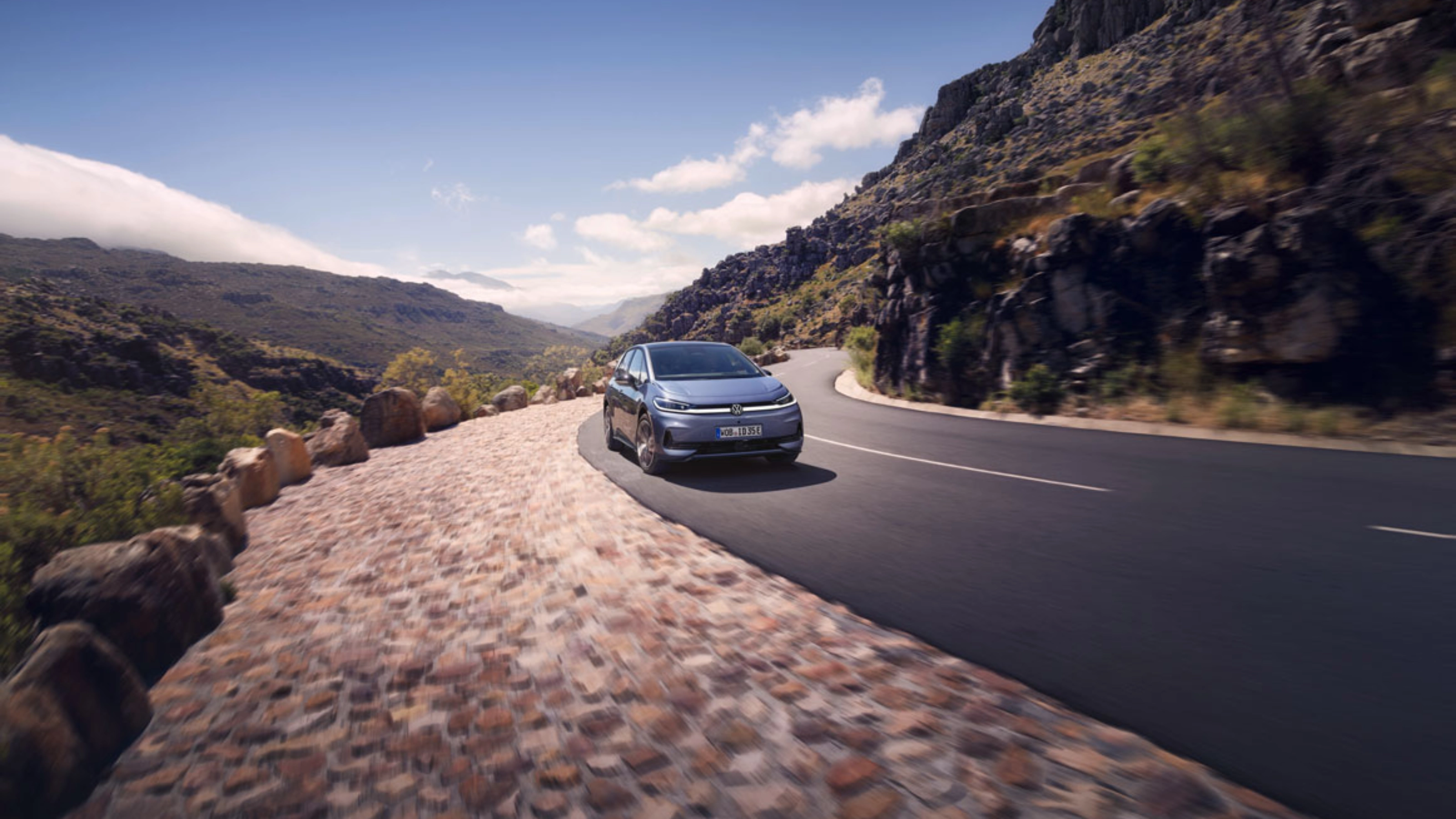 Volkswagen fährt auf einer Bergstraße mit felsiger Landschaft