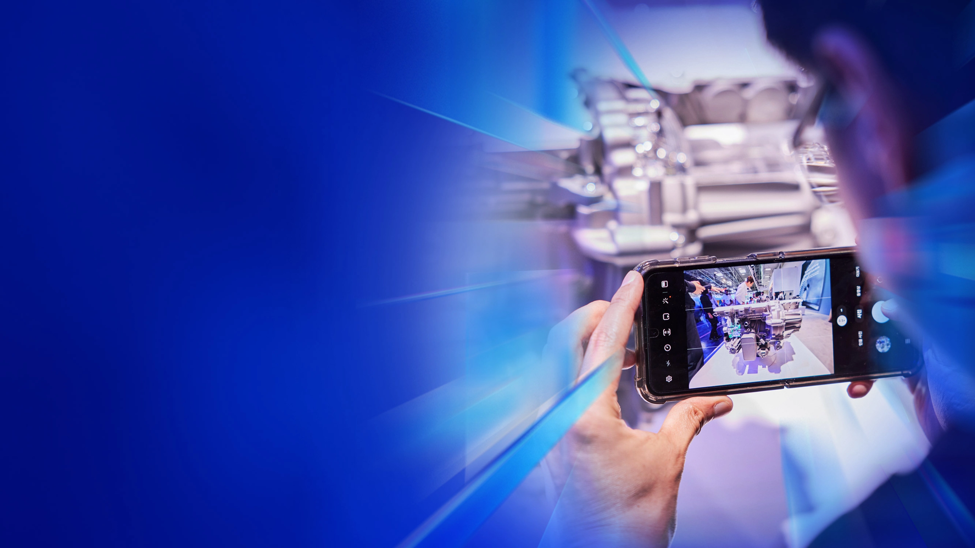 Eine Person fotografiert ein technisches Exponat mit dem Smartphone auf dem IAA Summit.