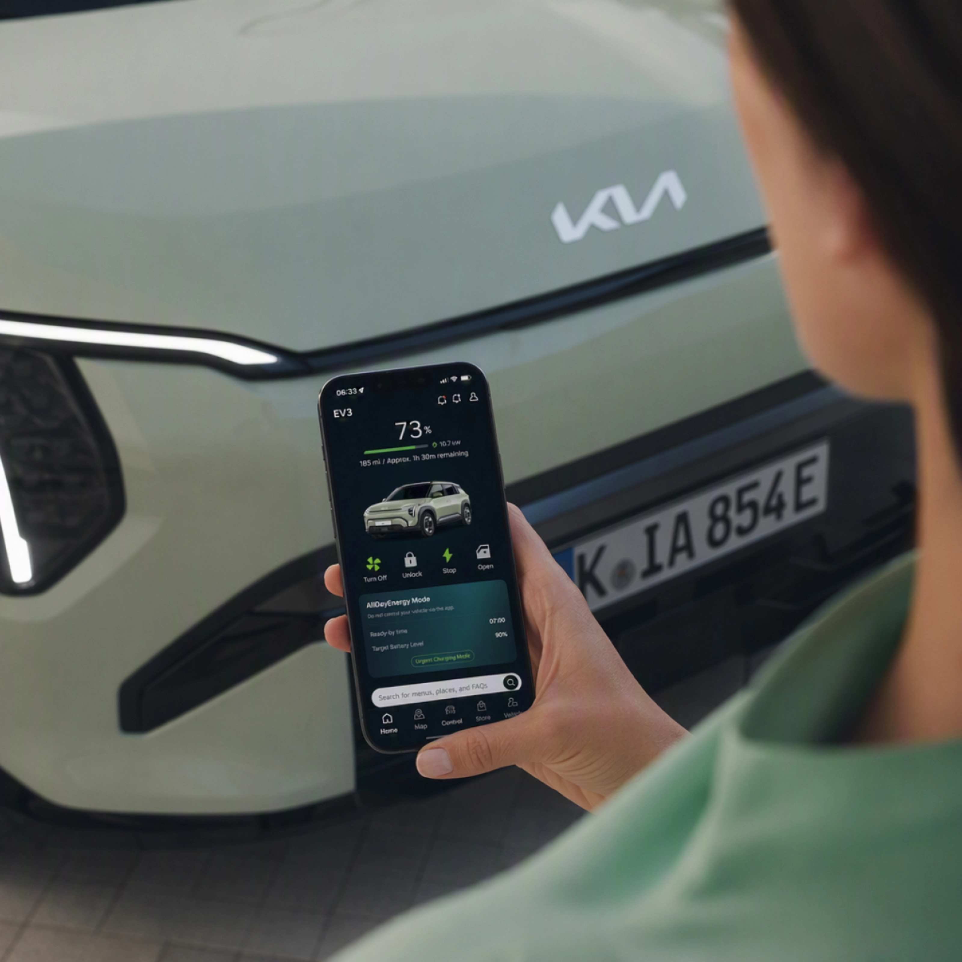 Person nutzt ein Smartphone vor einem Kia-Elektroauto