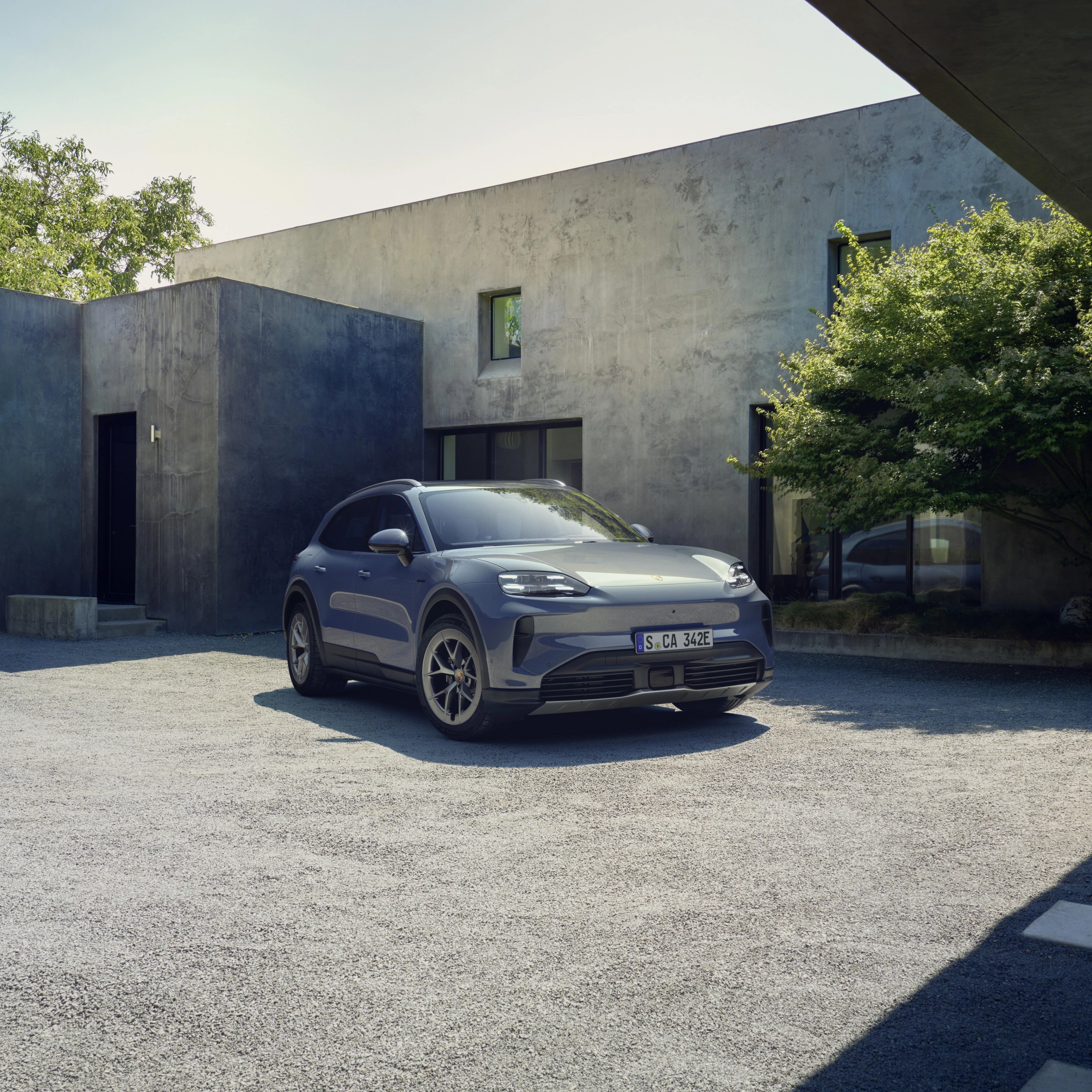 Porsche Cayenne S parked in front of a modern house.