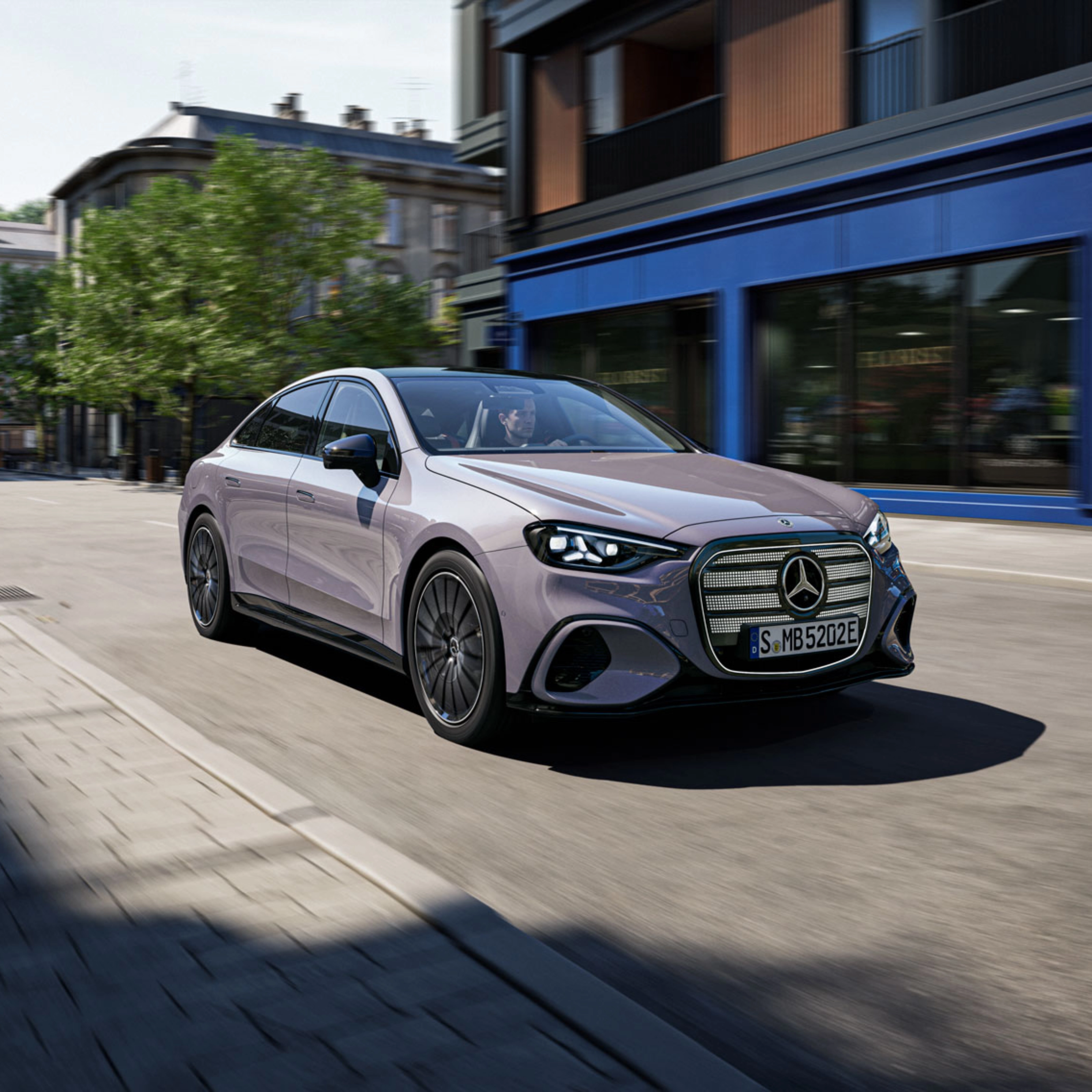 Graue Mercedes-Benz Limousine fährt durch eine Stadtstraße.