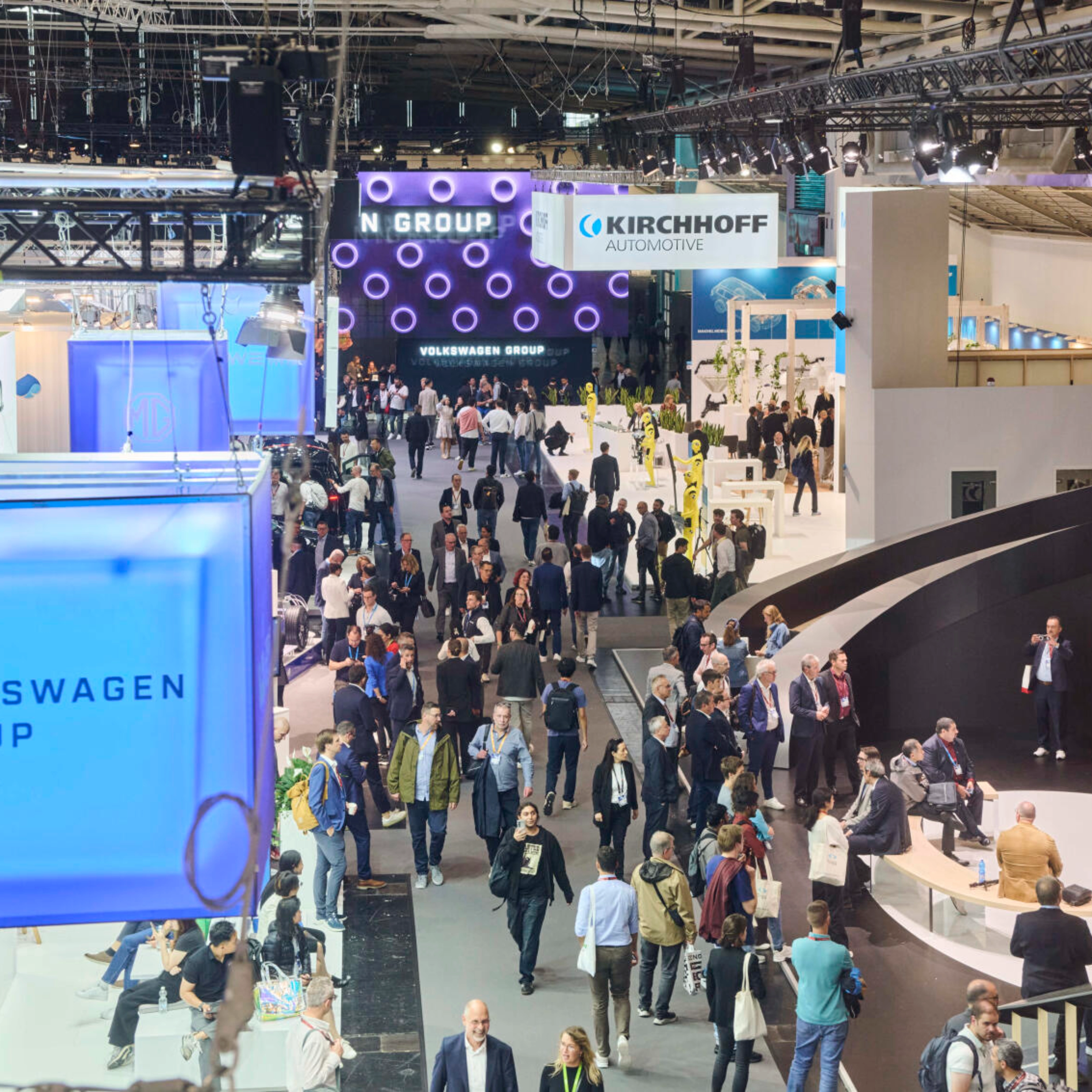 Menschen besuchen den Stand der Volkswagen Group auf einer Messe.