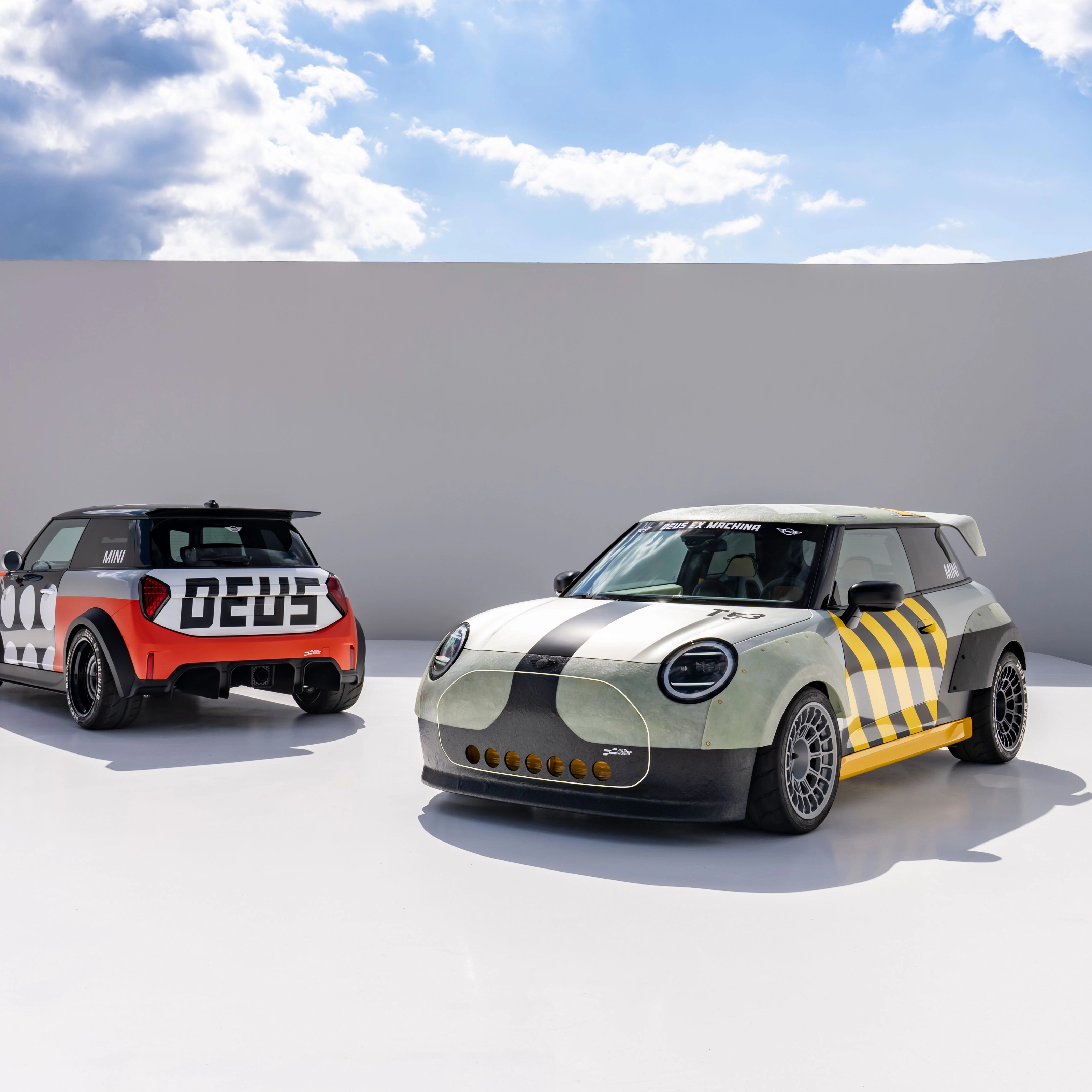 Two customized Mini cars parked in a minimalist outdoor setting.