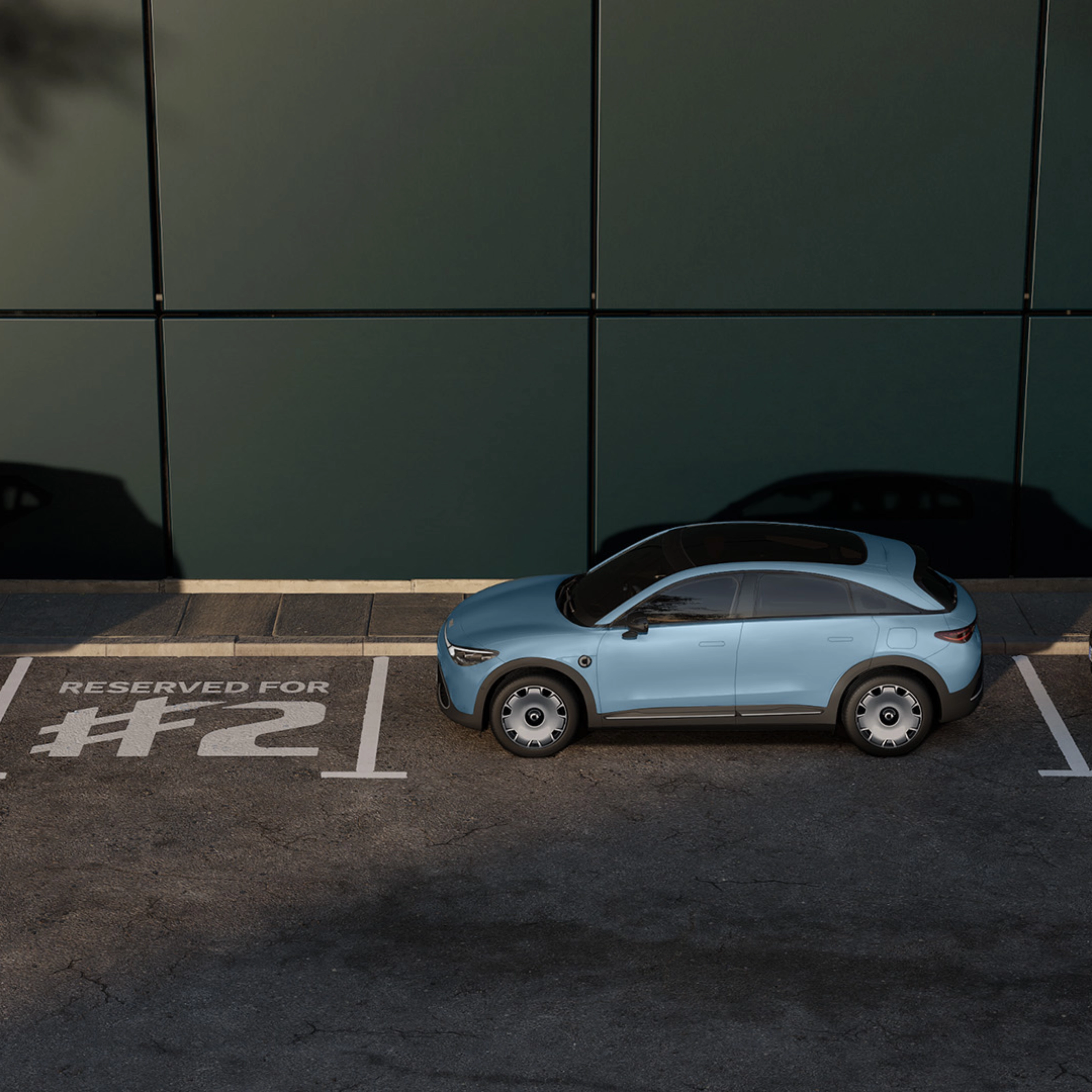 Three parked electric cars in front of a building, with one space marked "Reserved for #2".