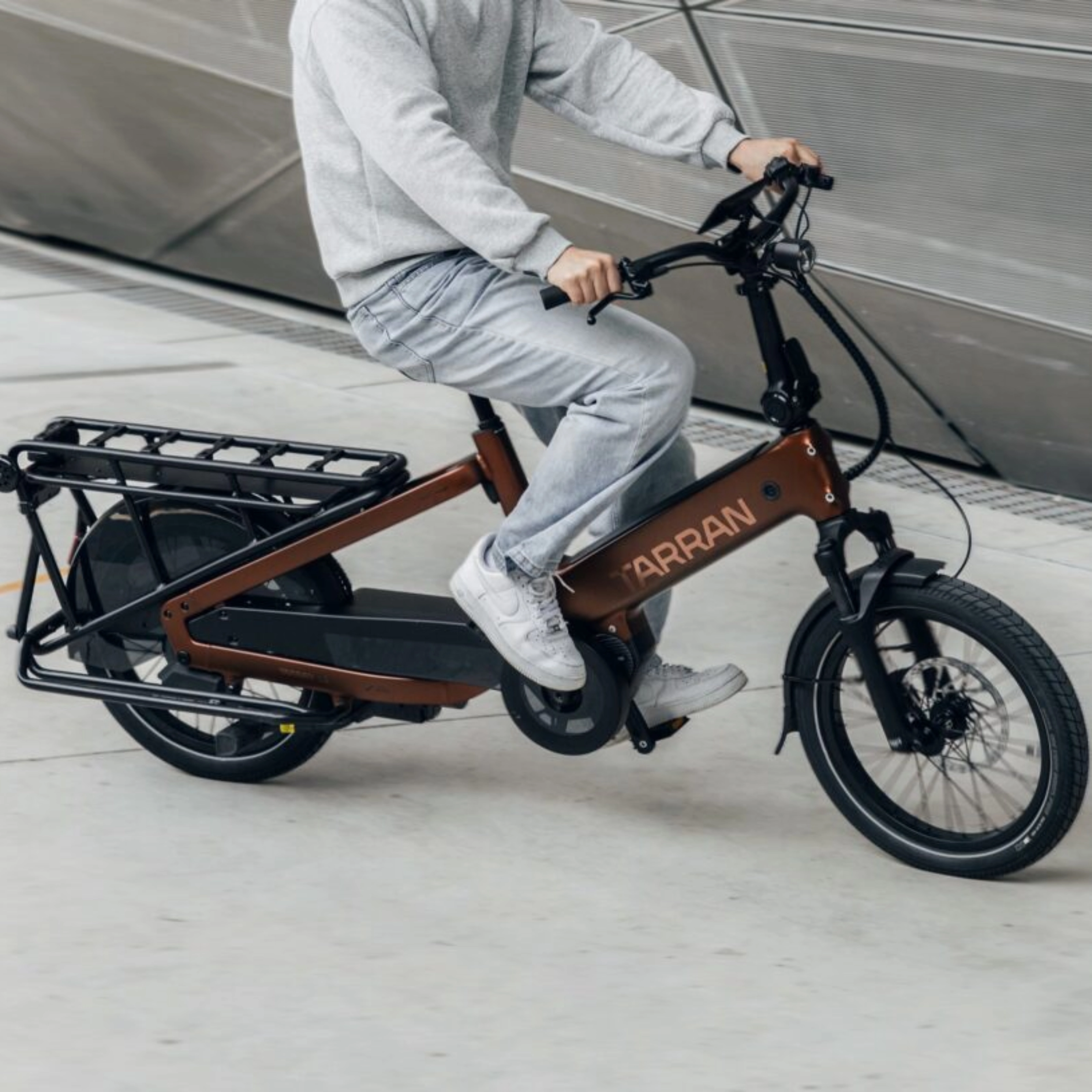 Person fährt ein Tarran Lasten-E-Bike in urbaner Umgebung.