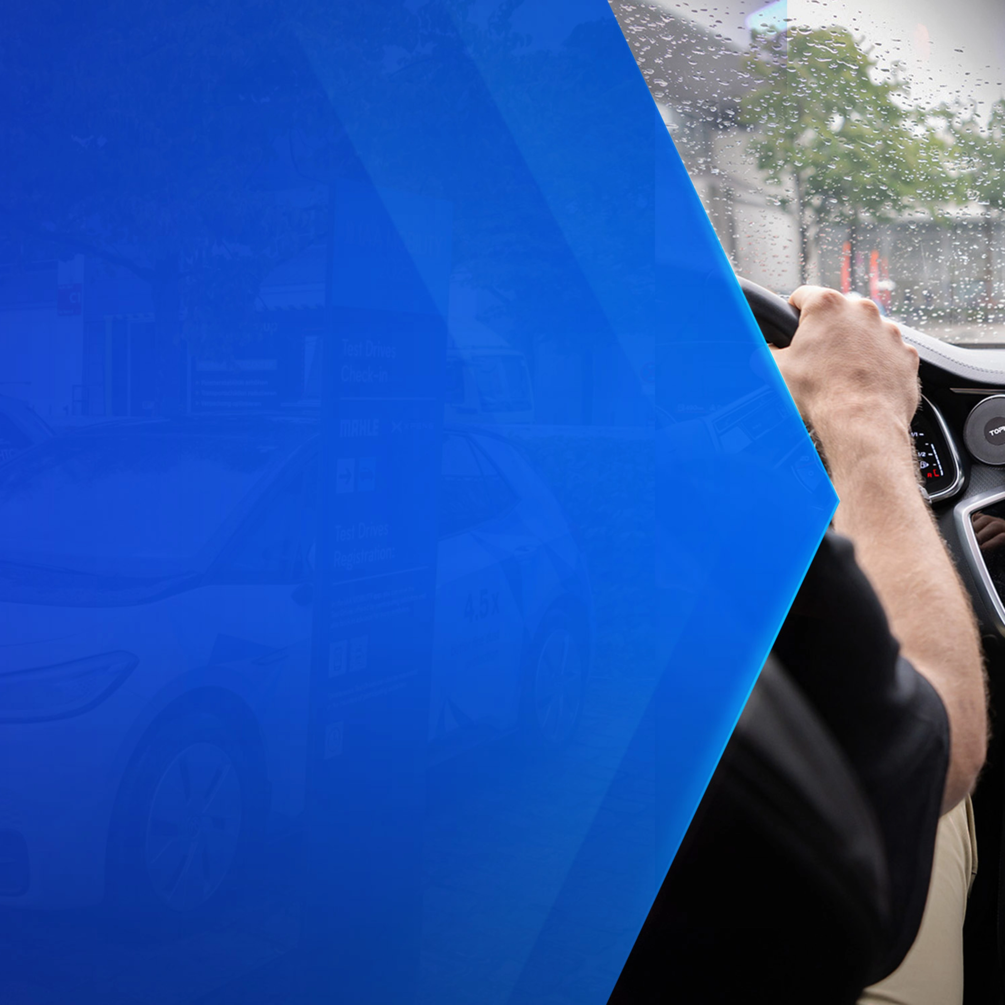 Driver tests in-car technology with navigation and monitoring screens during rainy conditions.