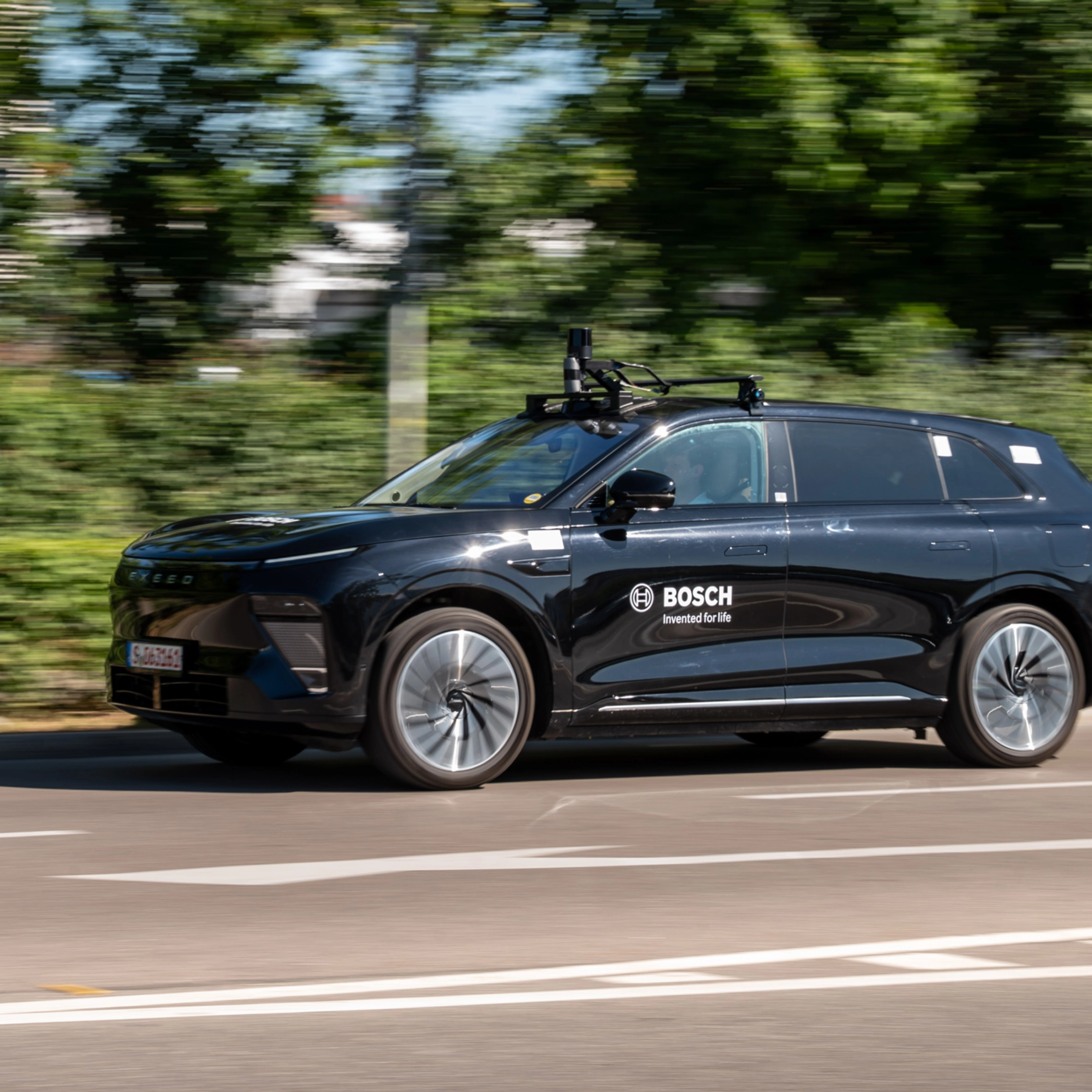 Schwarzer Bosch-Test-SUV mit Dachsensoren fährt auf Straße.