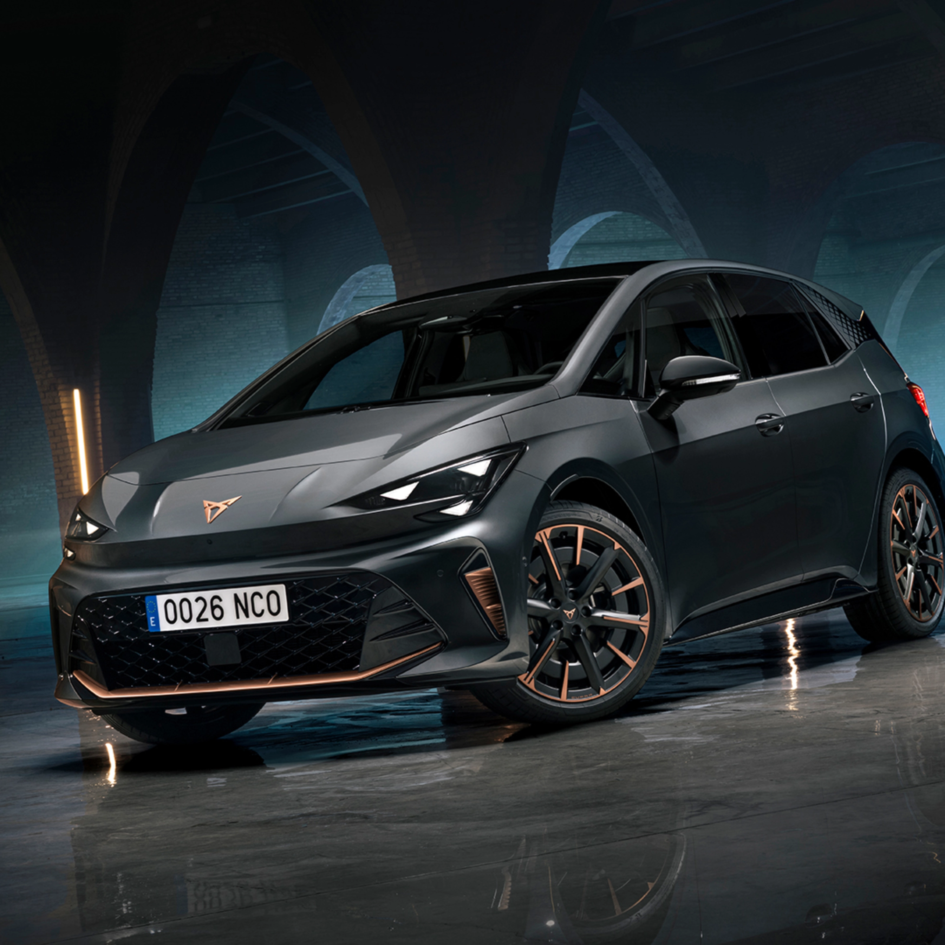CUPRA Elektroauto steht in einer dunklen Halle mit Bögen und spiegelndem Boden.