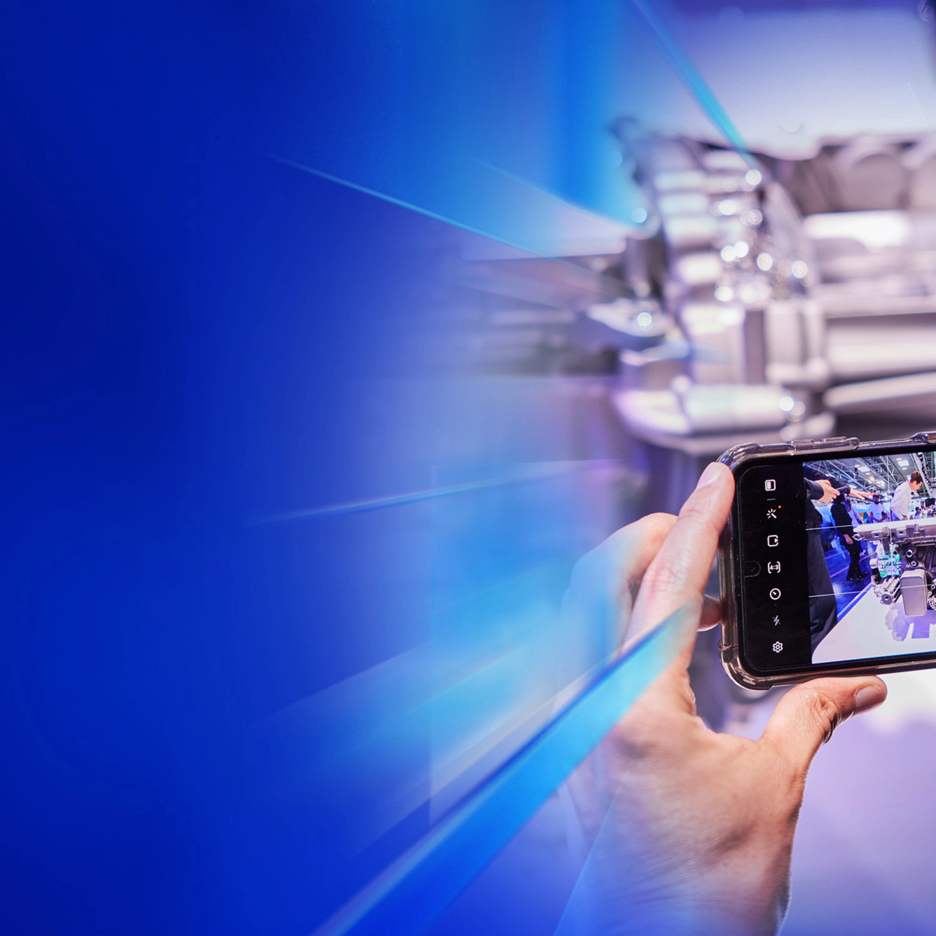 Eine Person fotografiert ein technisches Exponat mit dem Smartphone auf dem IAA Summit.