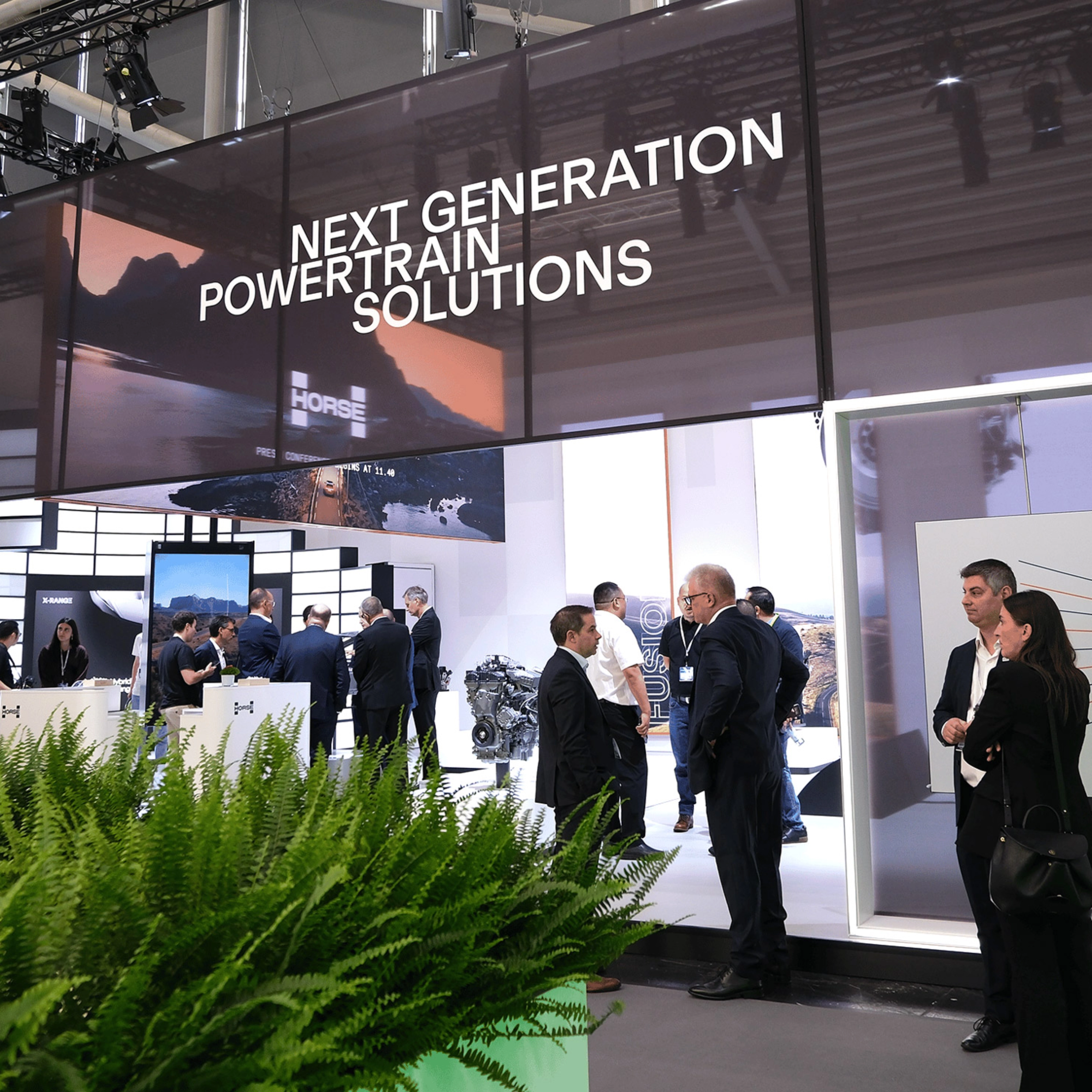 Horse Powertrain exhibition booth with visitors at an automotive trade show.