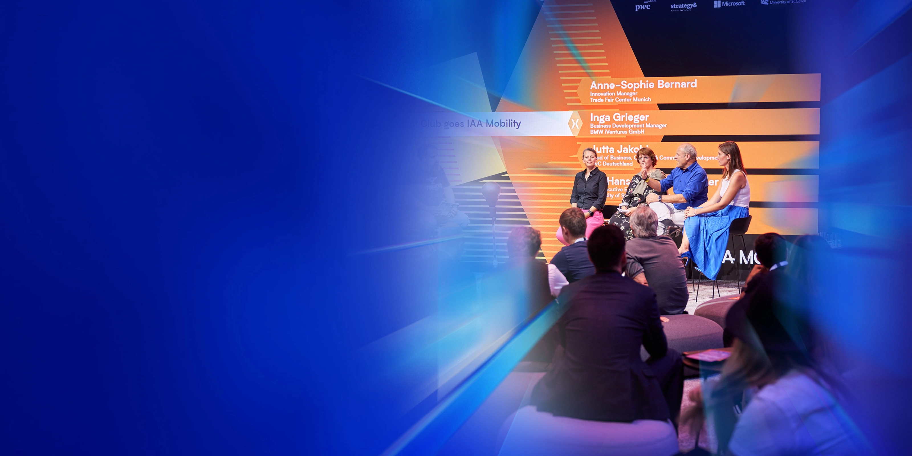 Ein Panel mit fünf Personen spricht auf der Bühne des IAA Summit, das Publikum hört zu.