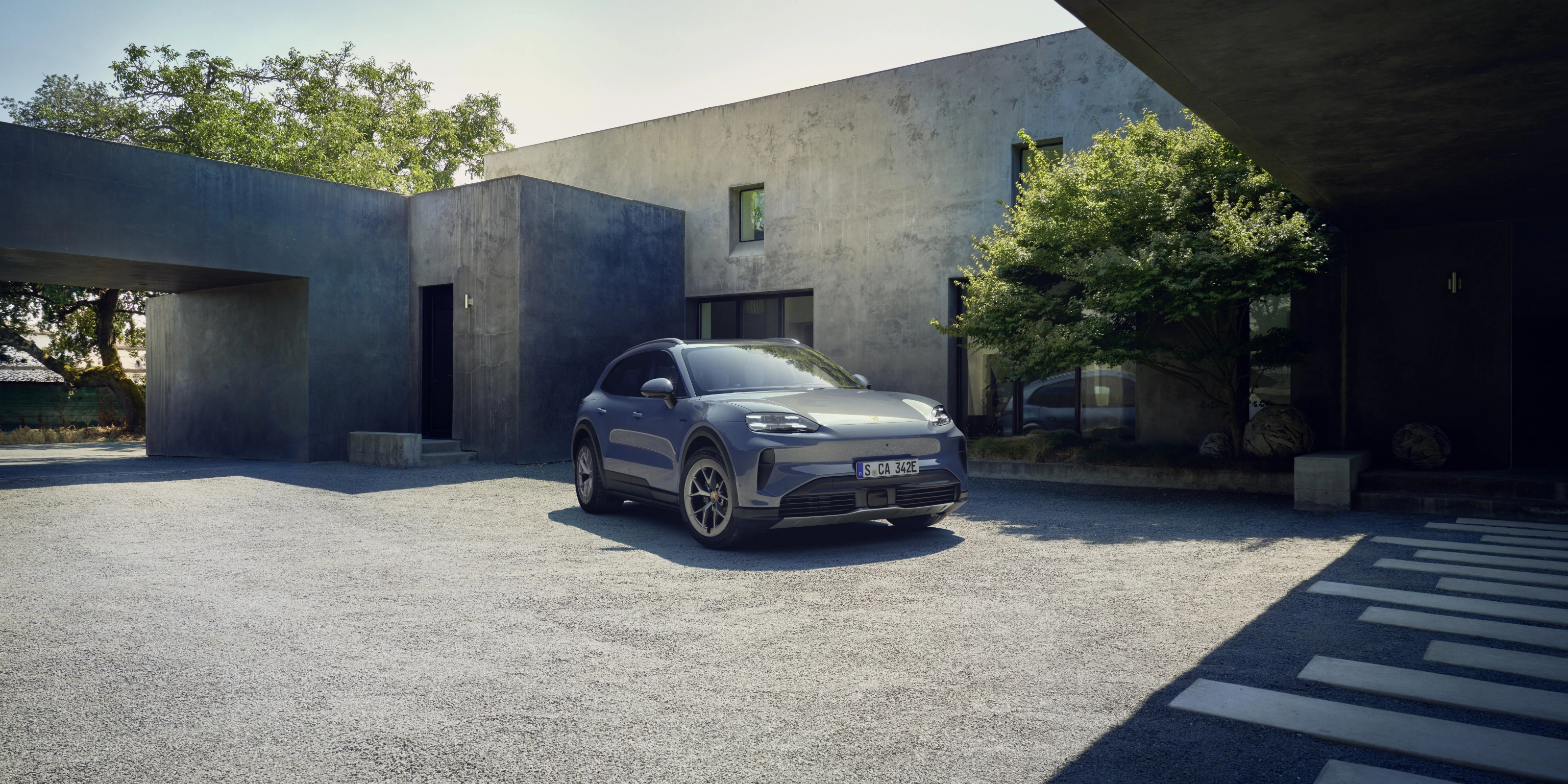 Porsche Cayenne S parked in front of a modern house.