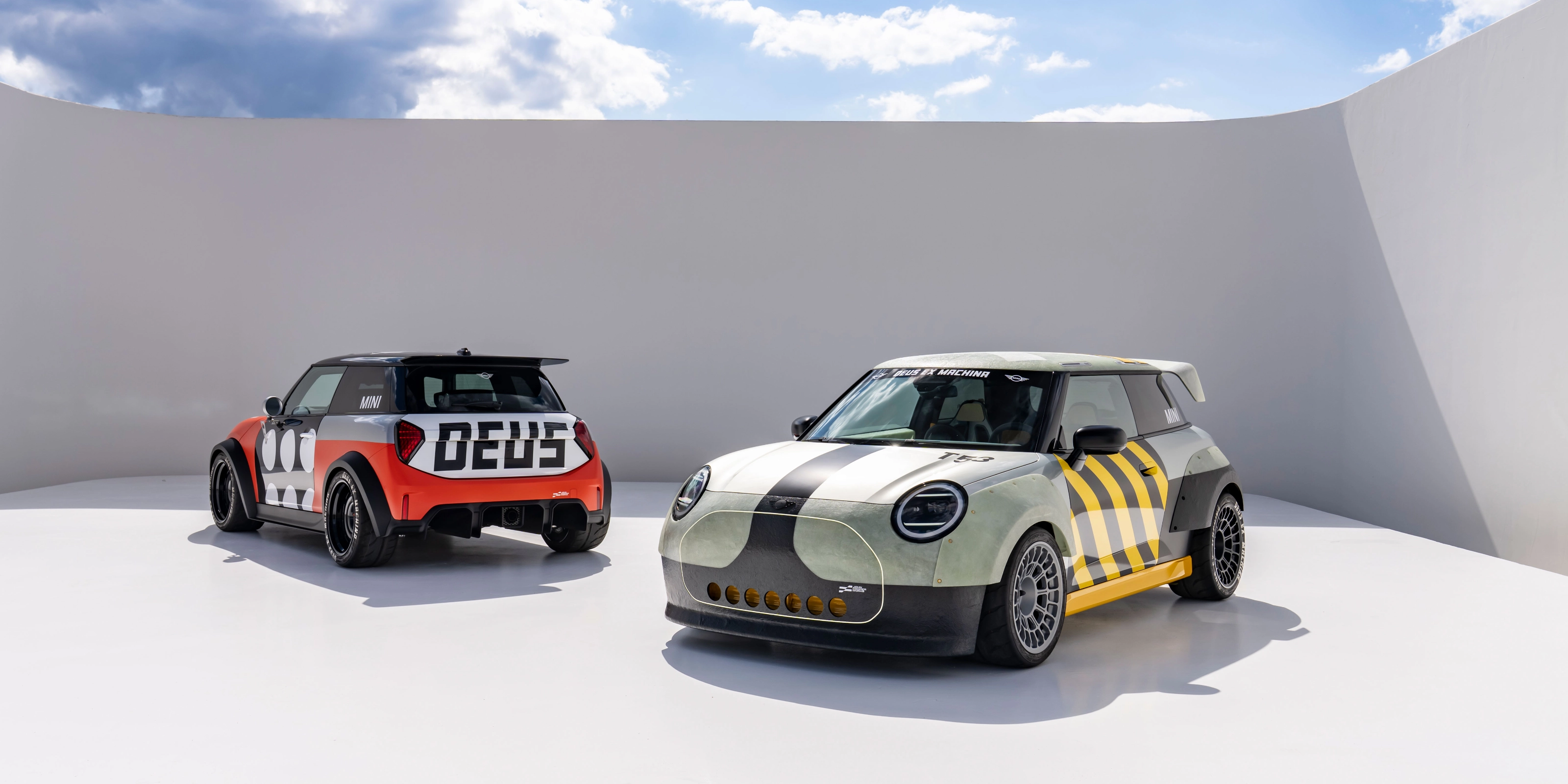 Two customized Mini cars parked in a minimalist outdoor setting.