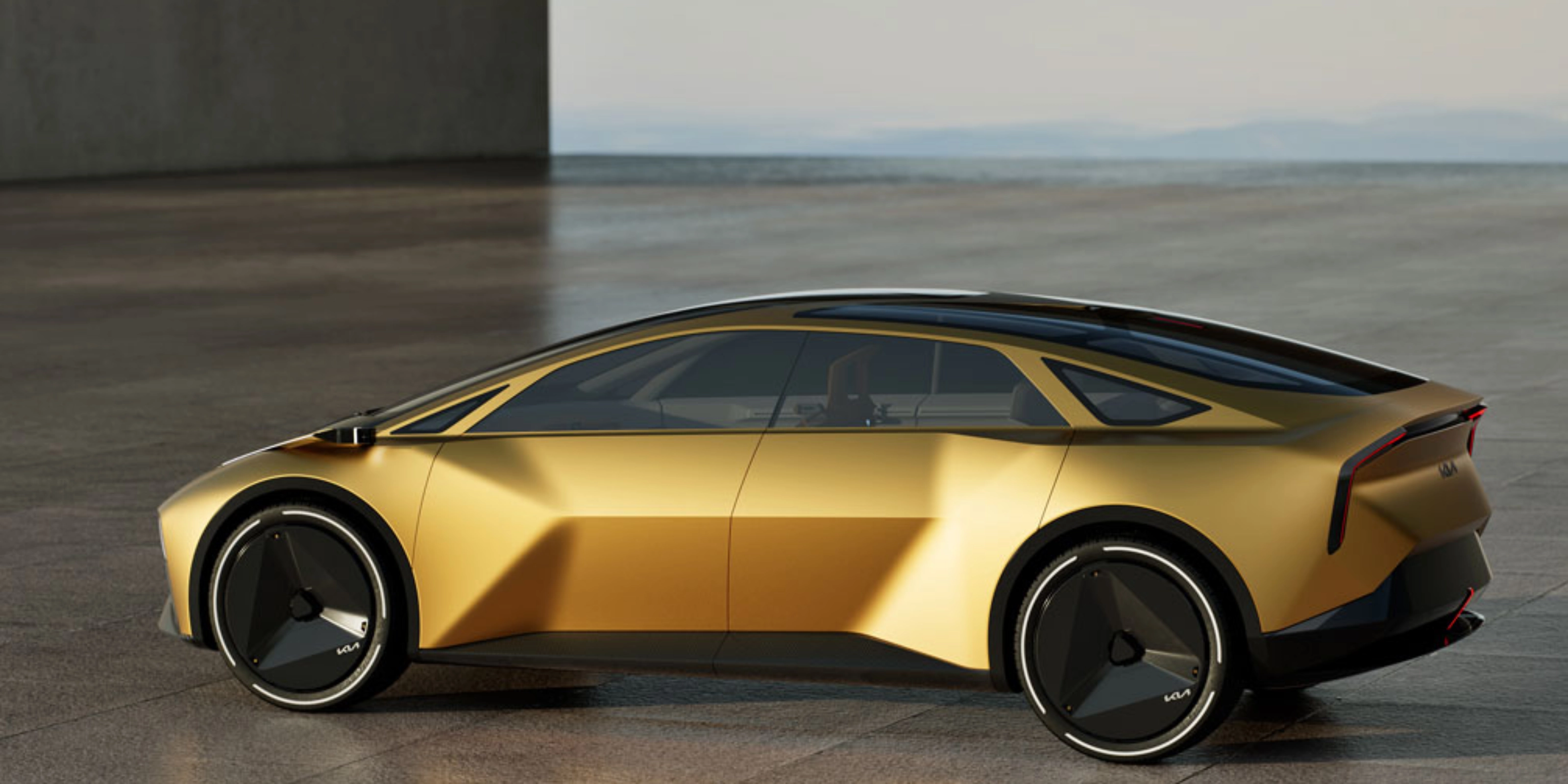 Goldenes Konzeptauto in Seitenansicht auf freier Betonfläche.