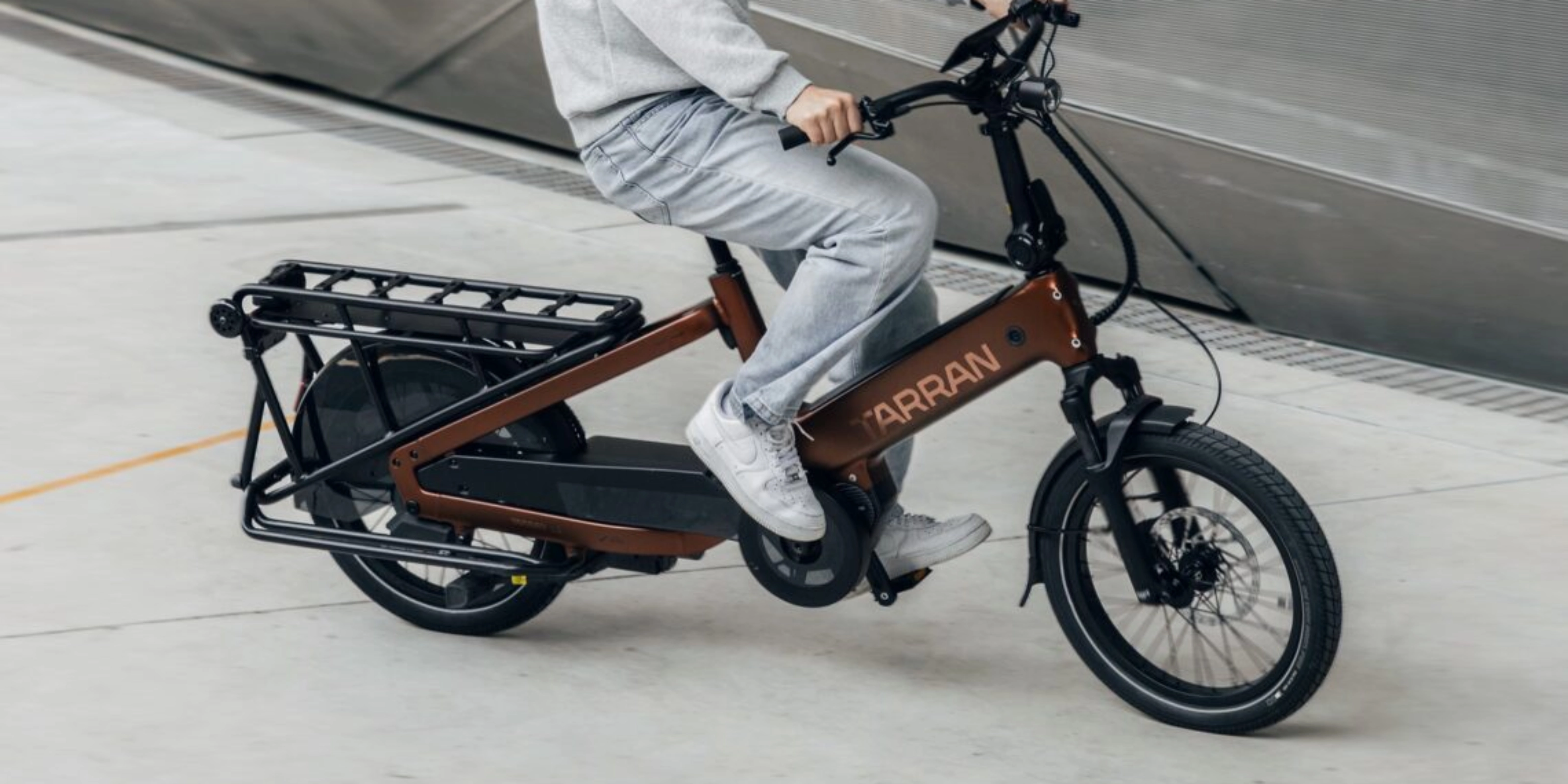 Person fährt ein Tarran Lasten-E-Bike in urbaner Umgebung.