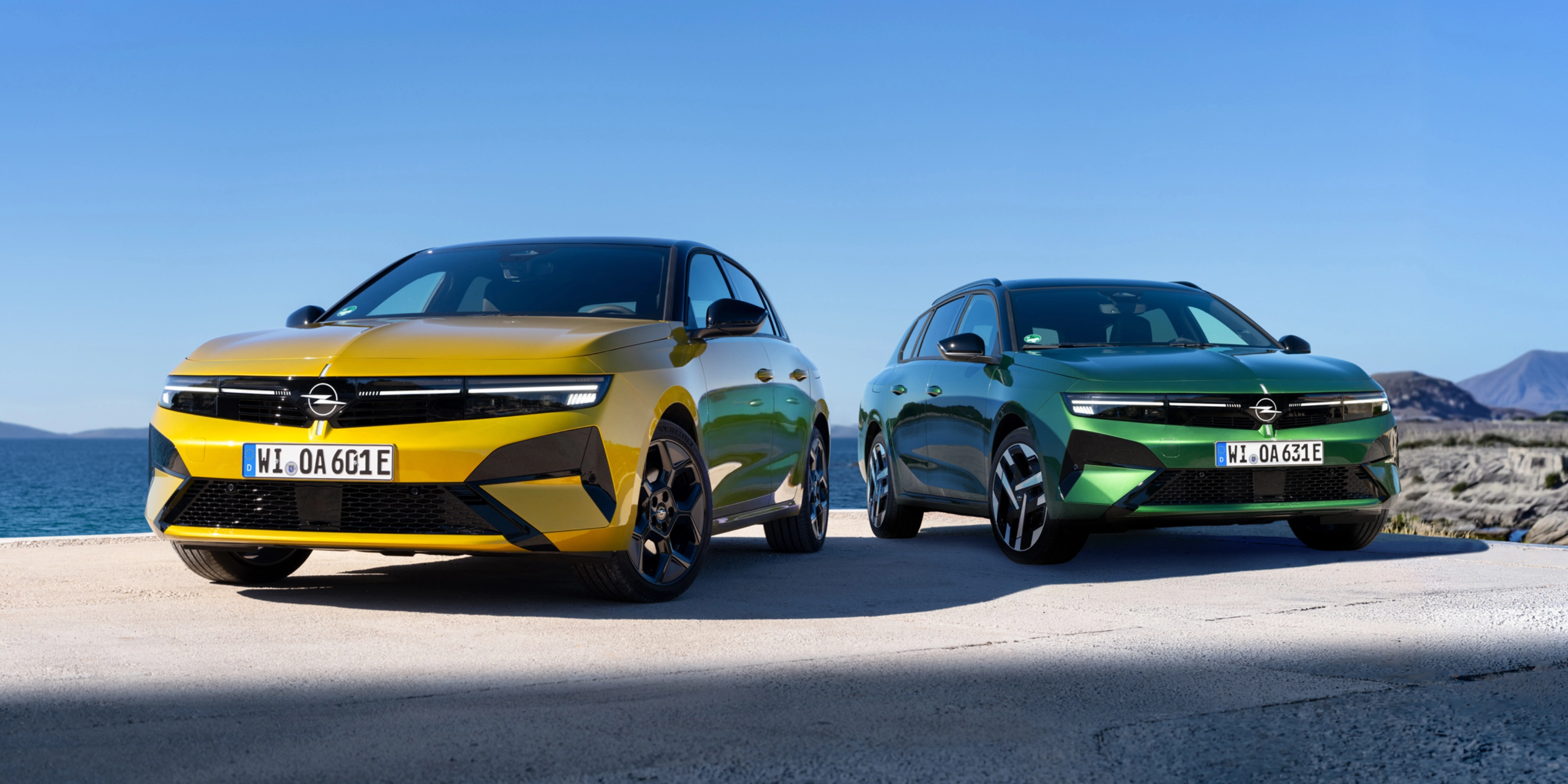 Gelber und grüner Opel stehen nebeneinander am Meer.