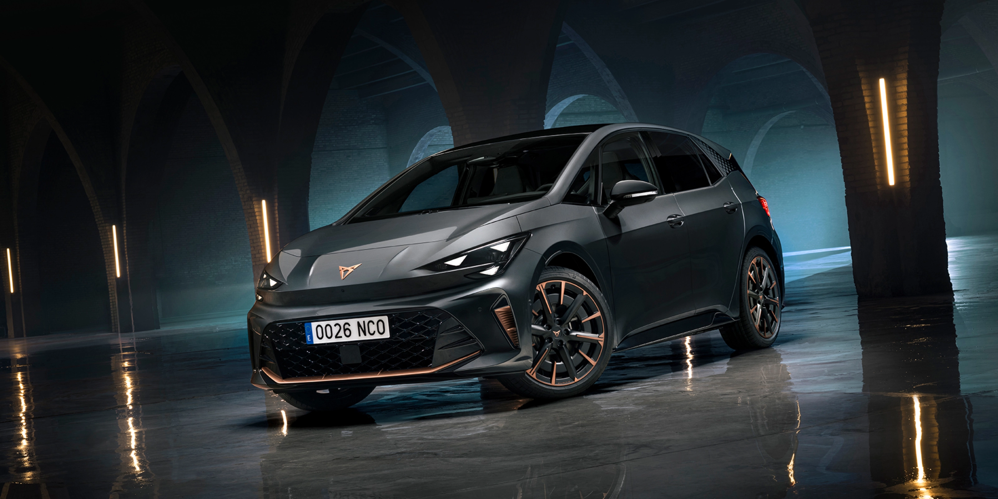CUPRA Elektroauto steht in einer dunklen Halle mit Bögen und spiegelndem Boden.