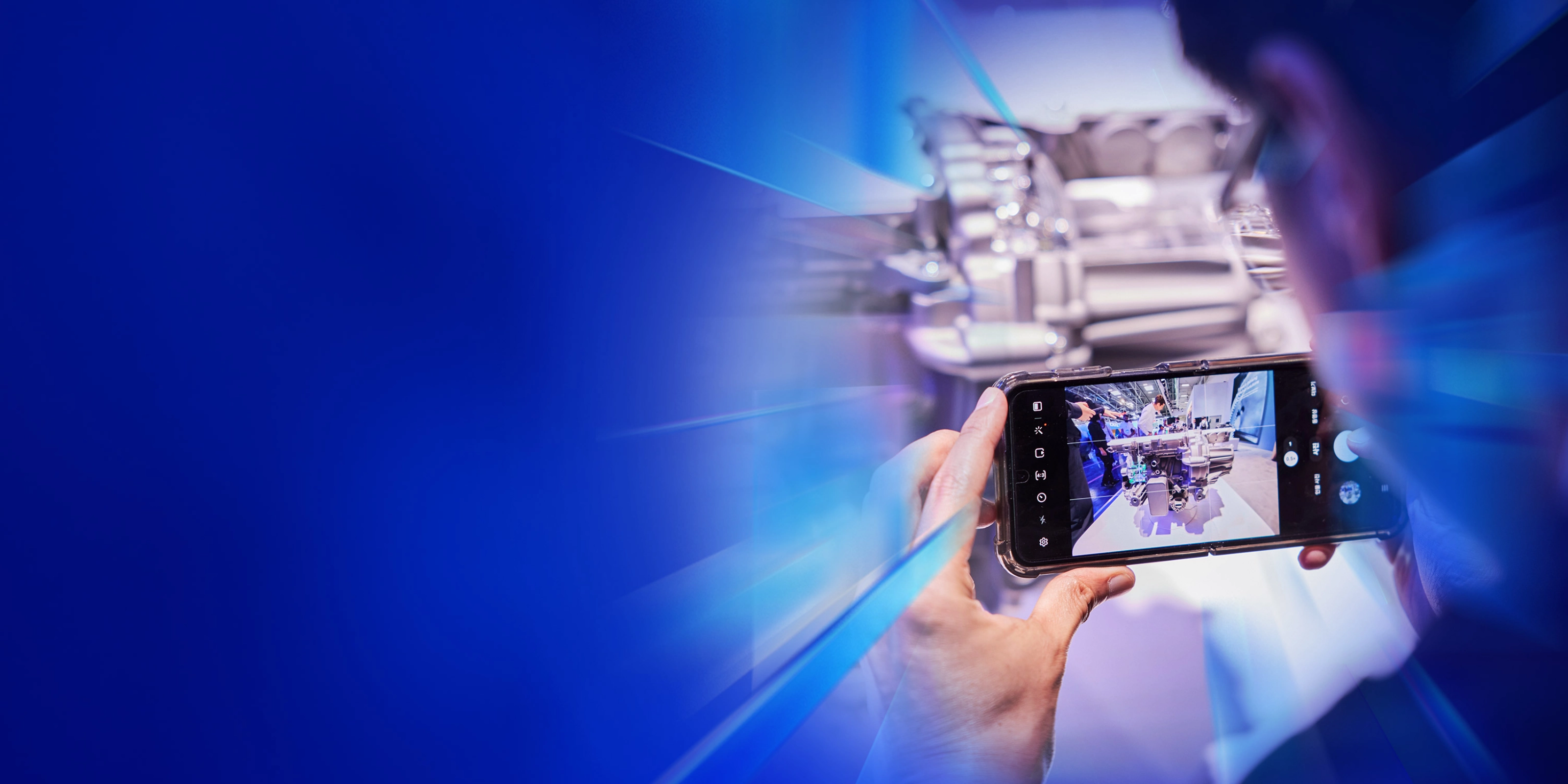 Eine Person fotografiert ein technisches Exponat mit dem Smartphone auf dem IAA Summit.