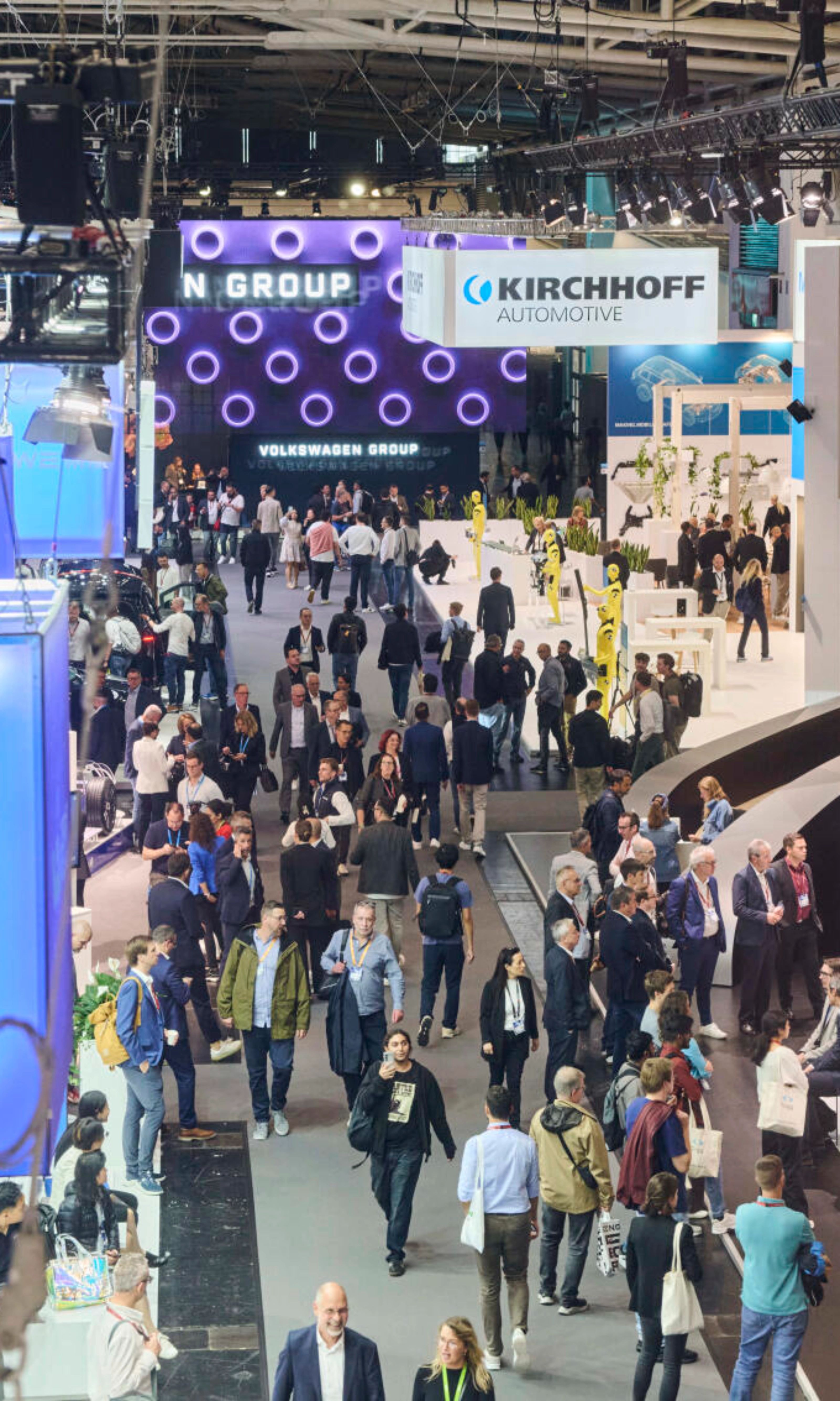 Menschen besuchen den Stand der Volkswagen Group auf einer Messe.