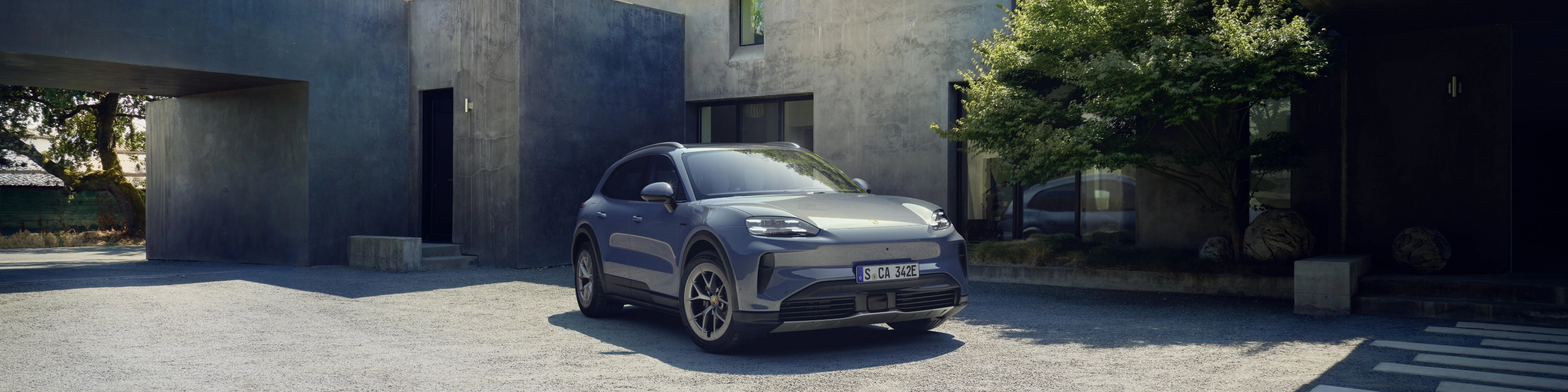 Porsche Cayenne S parked in front of a modern house.