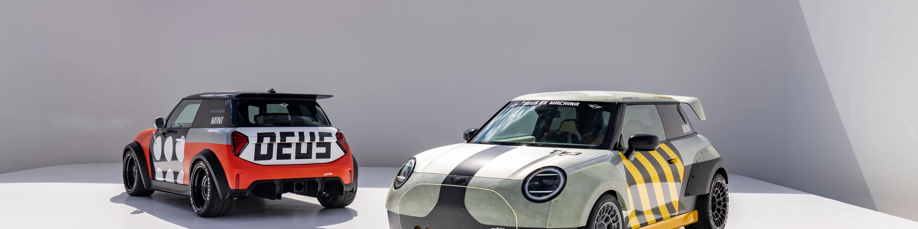 Two customized Mini cars parked in a minimalist outdoor setting.
