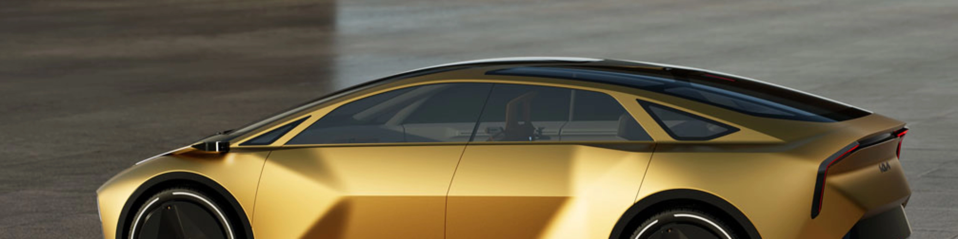 Goldenes Konzeptauto in Seitenansicht auf freier Betonfläche.