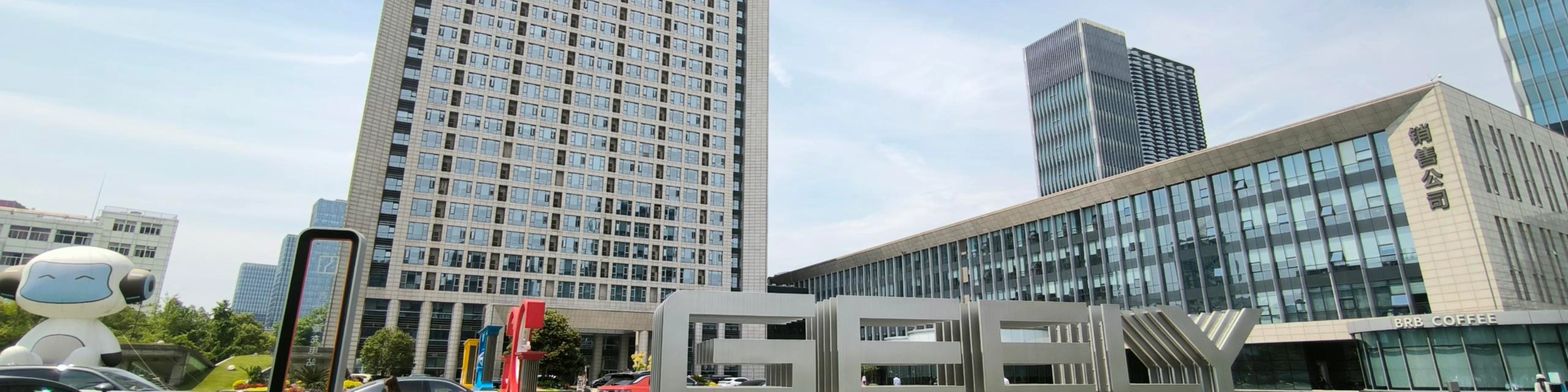 Geely-Logo vor einem modernen Bürogebäude.