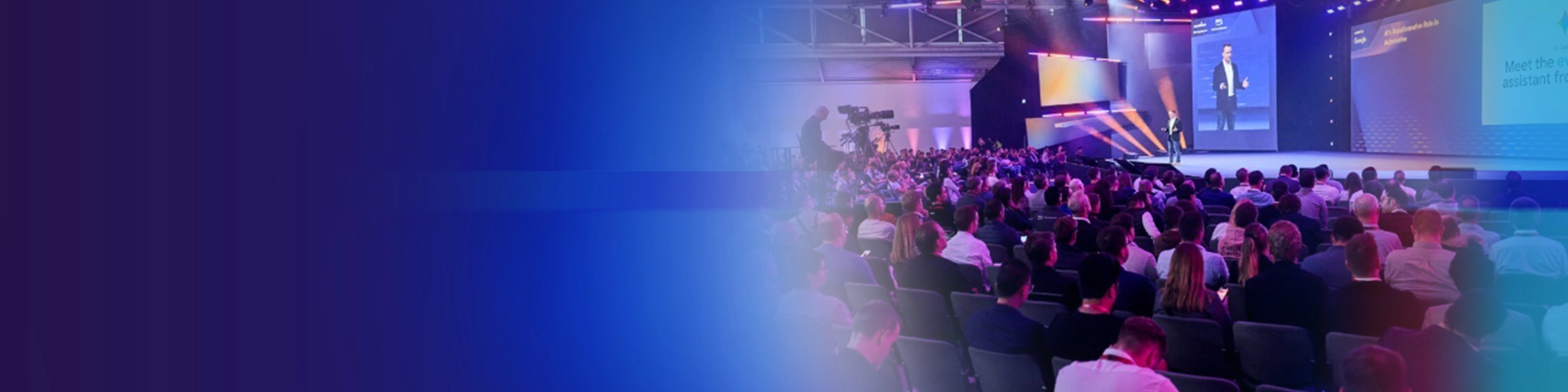 Promotional banner showing a conference audience and stage presentation.