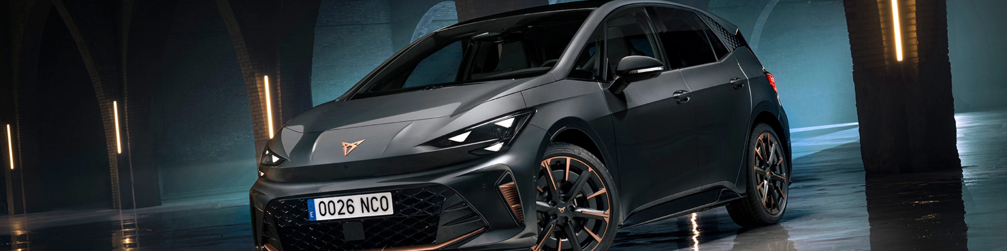 CUPRA Elektroauto steht in einer dunklen Halle mit Bögen und spiegelndem Boden.