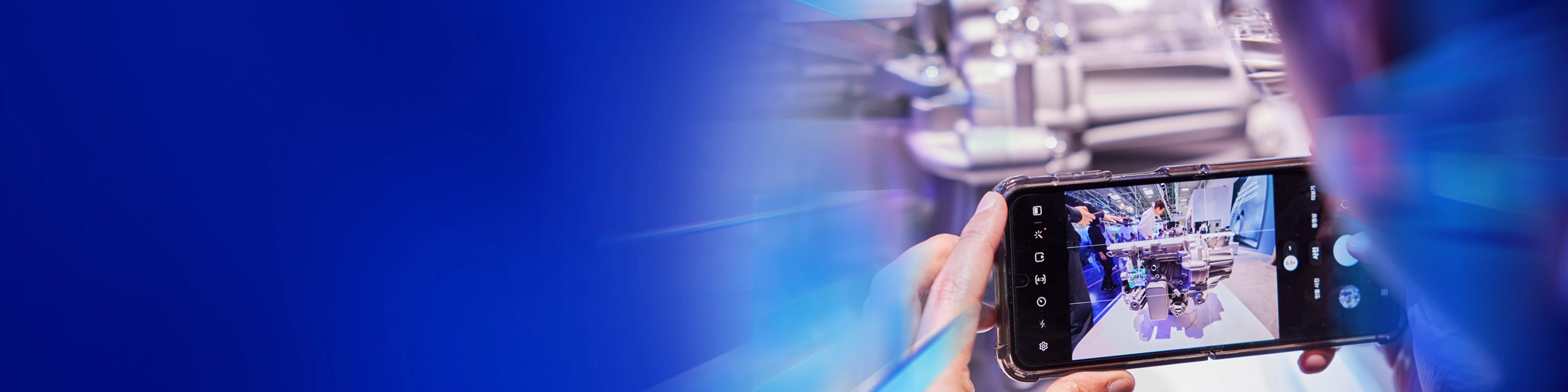 Eine Person fotografiert ein technisches Exponat mit dem Smartphone auf dem IAA Summit.