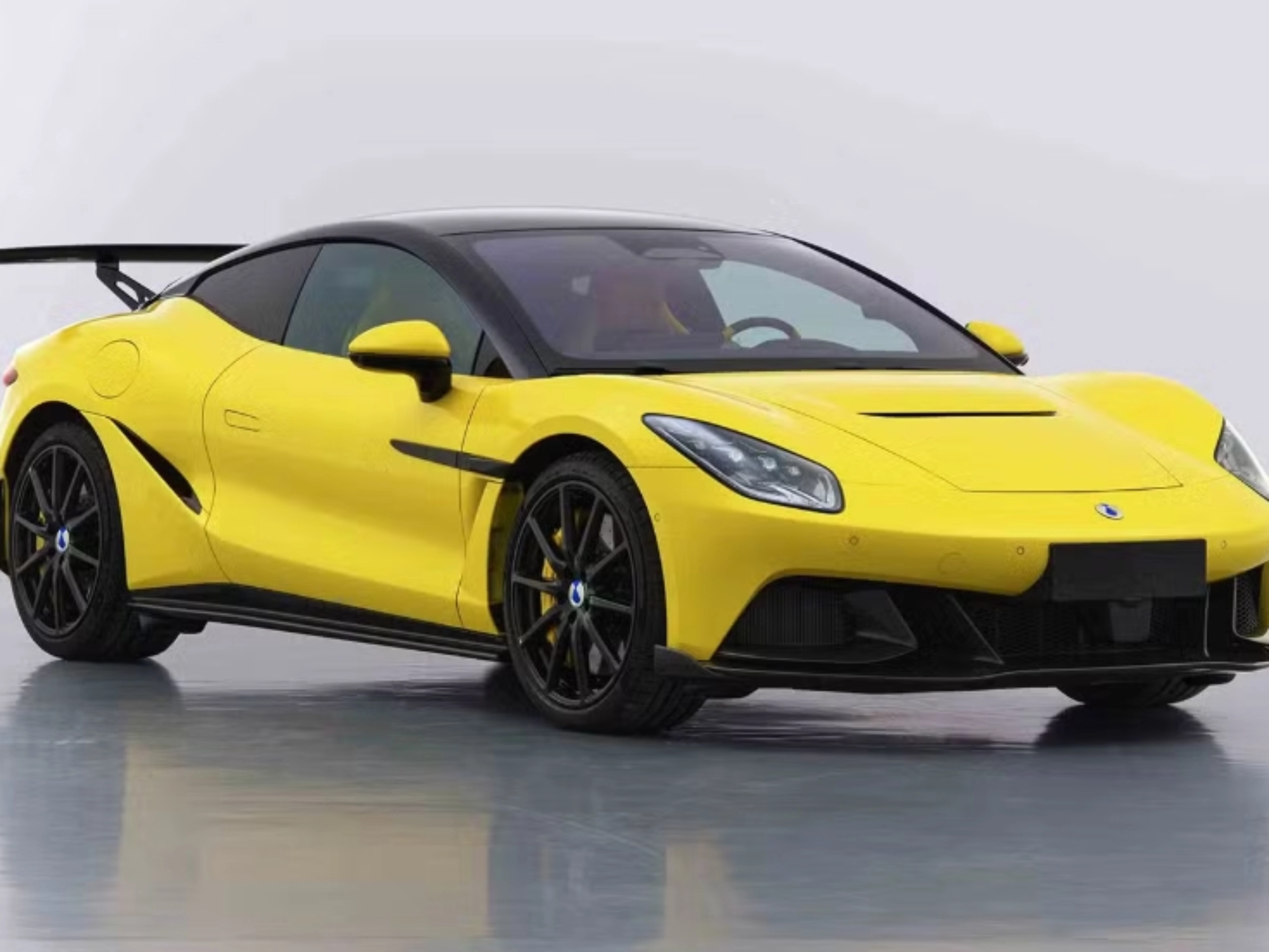 Yellow Denza Z sports car by BYD with rear wing on white studio background.