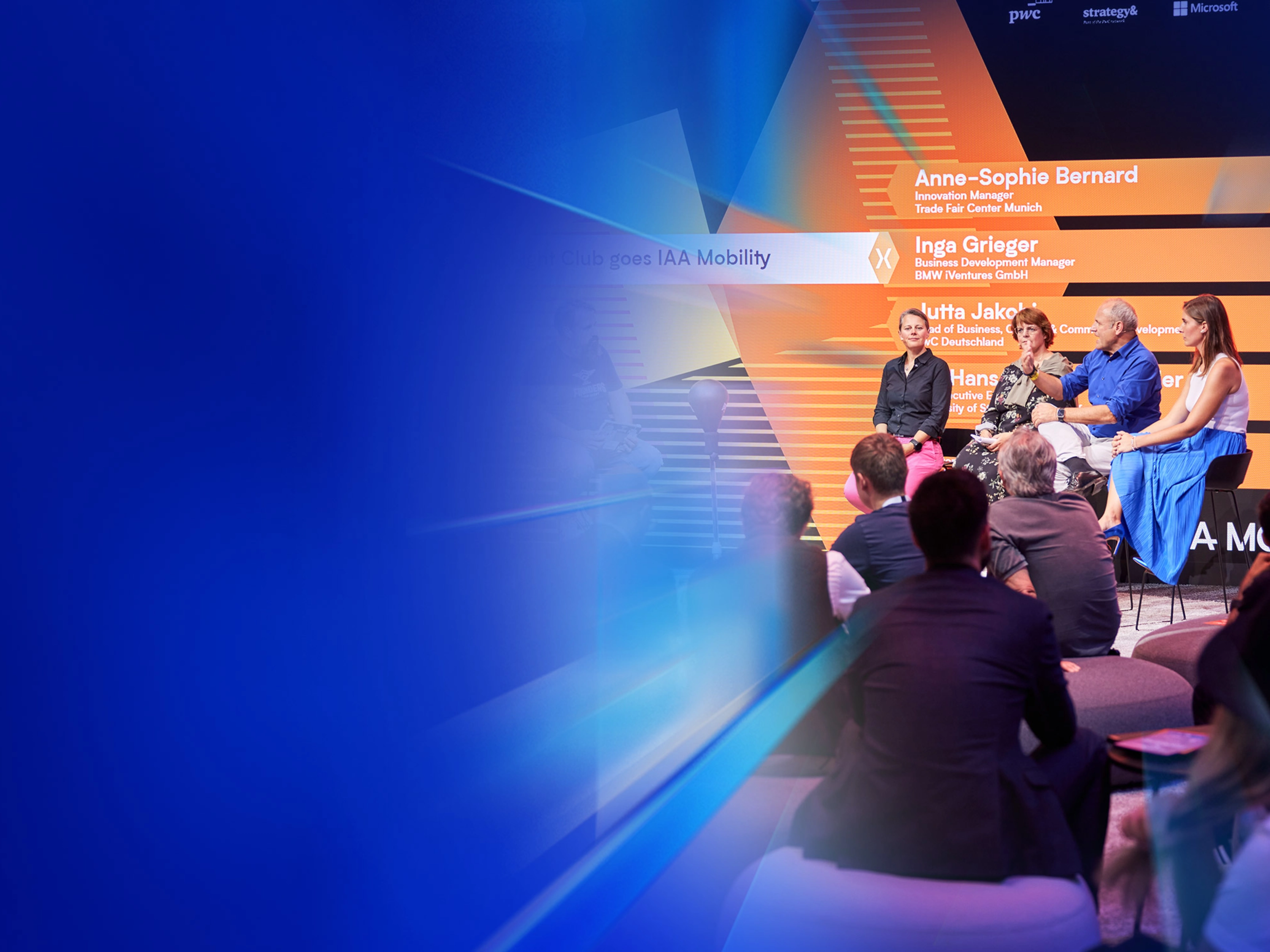 Ein Panel mit fünf Personen spricht auf der Bühne des IAA Summit, das Publikum hört zu.