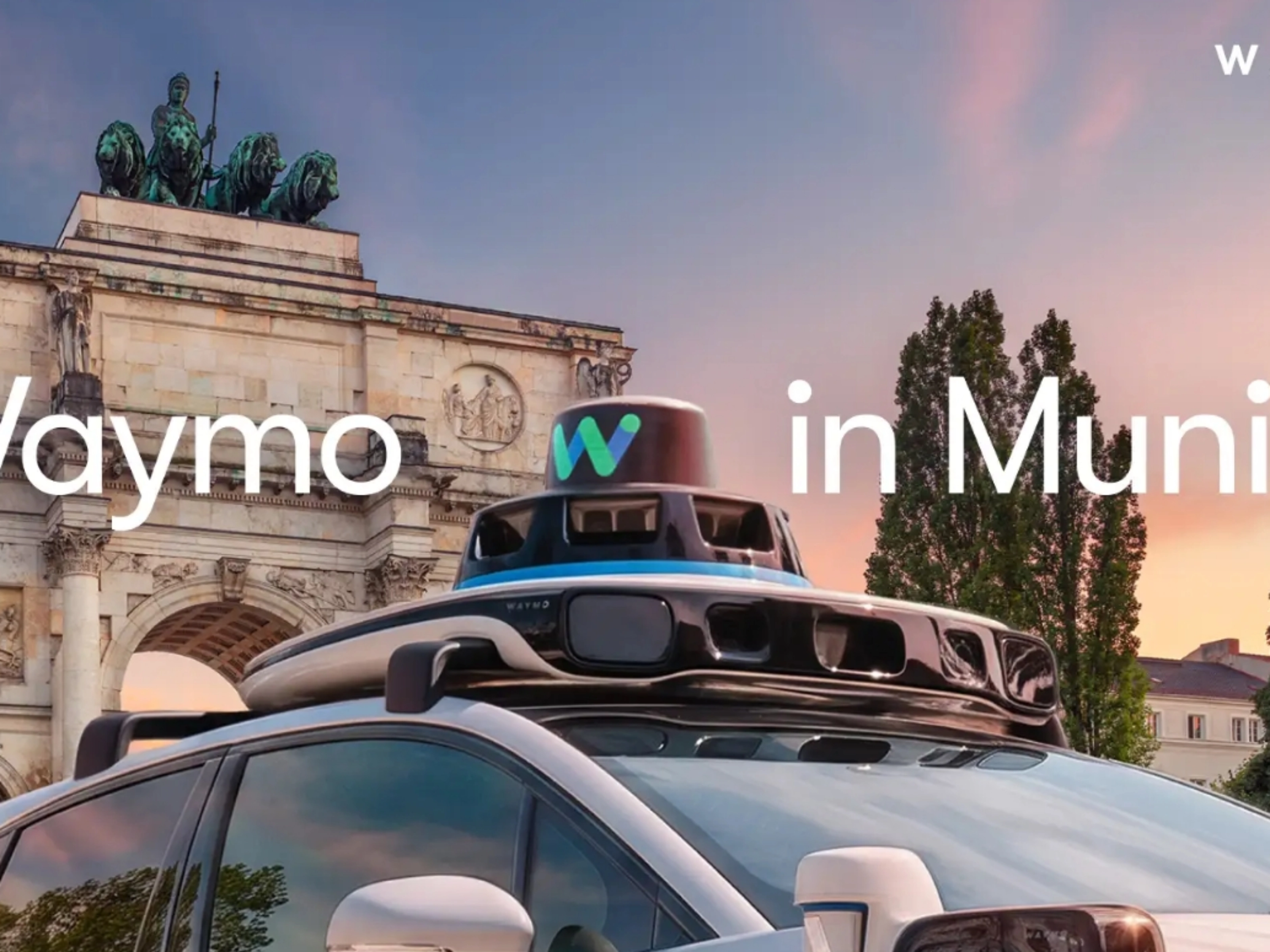 Autonomes Waymo Fahrzeug mit Dachsensoren vor einem Münchner Wahrzeichen.