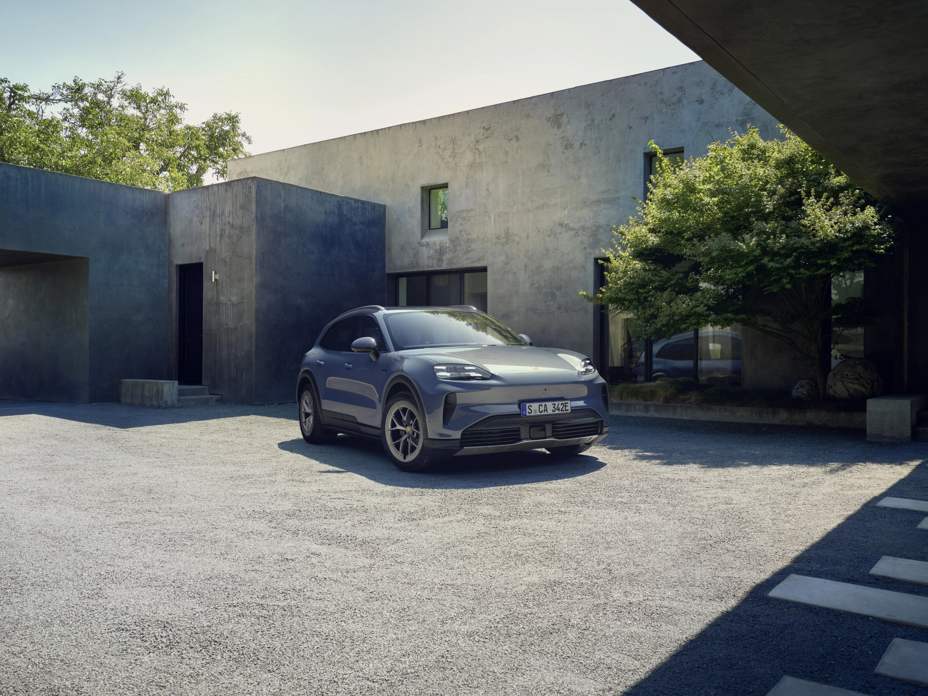 Porsche Cayenne S parked in front of a modern house.
