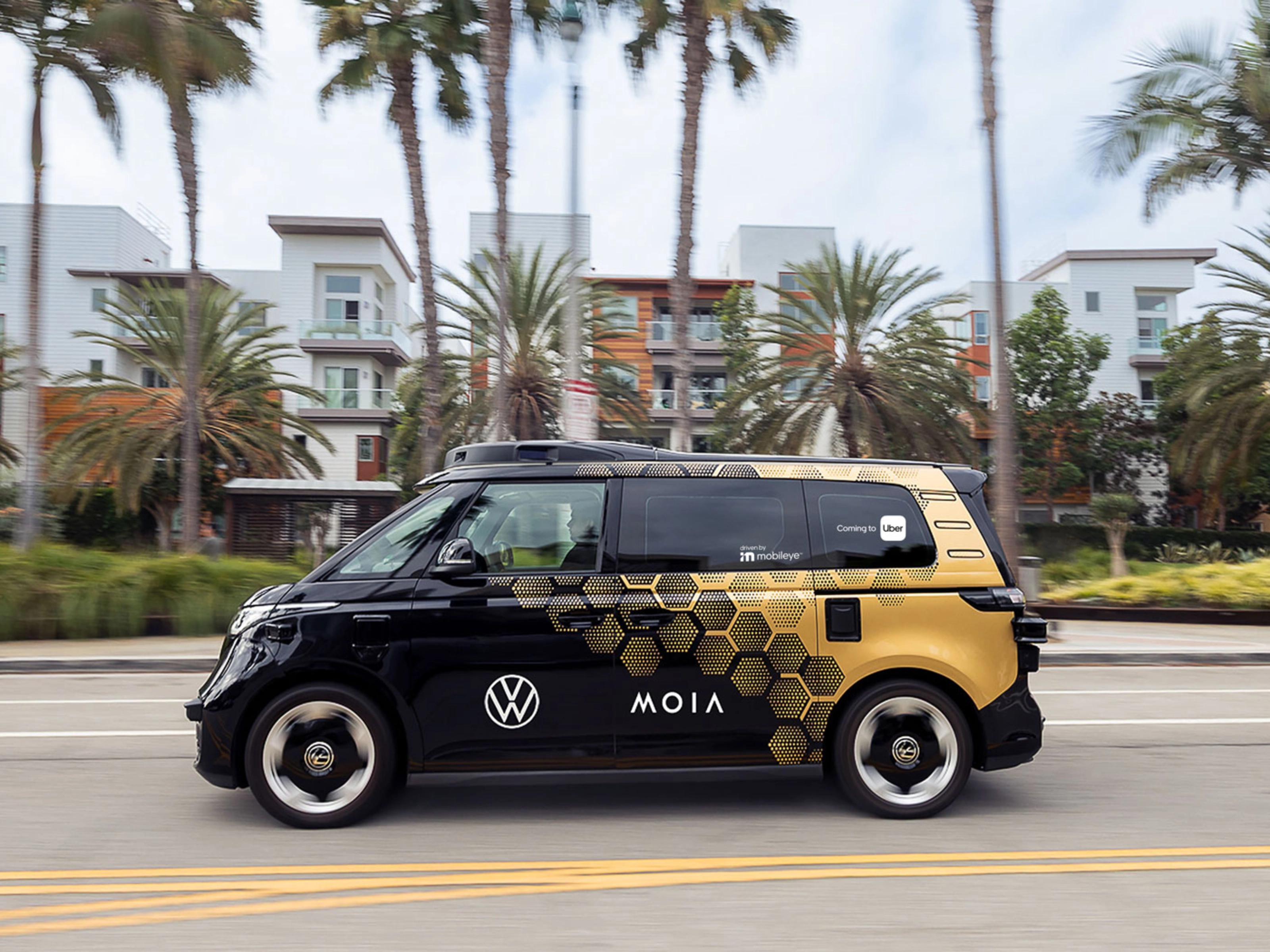 MOIA Elektro Shuttle fährt auf einer Straße mit Palmen