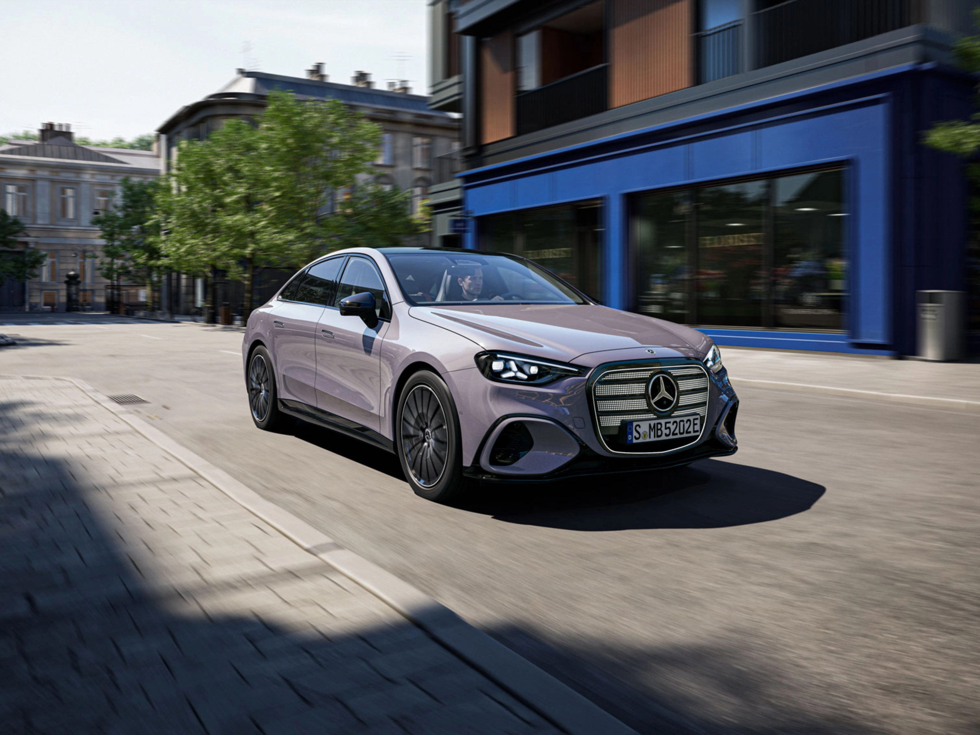 Graue Mercedes-Benz Limousine fährt durch eine Stadtstraße.